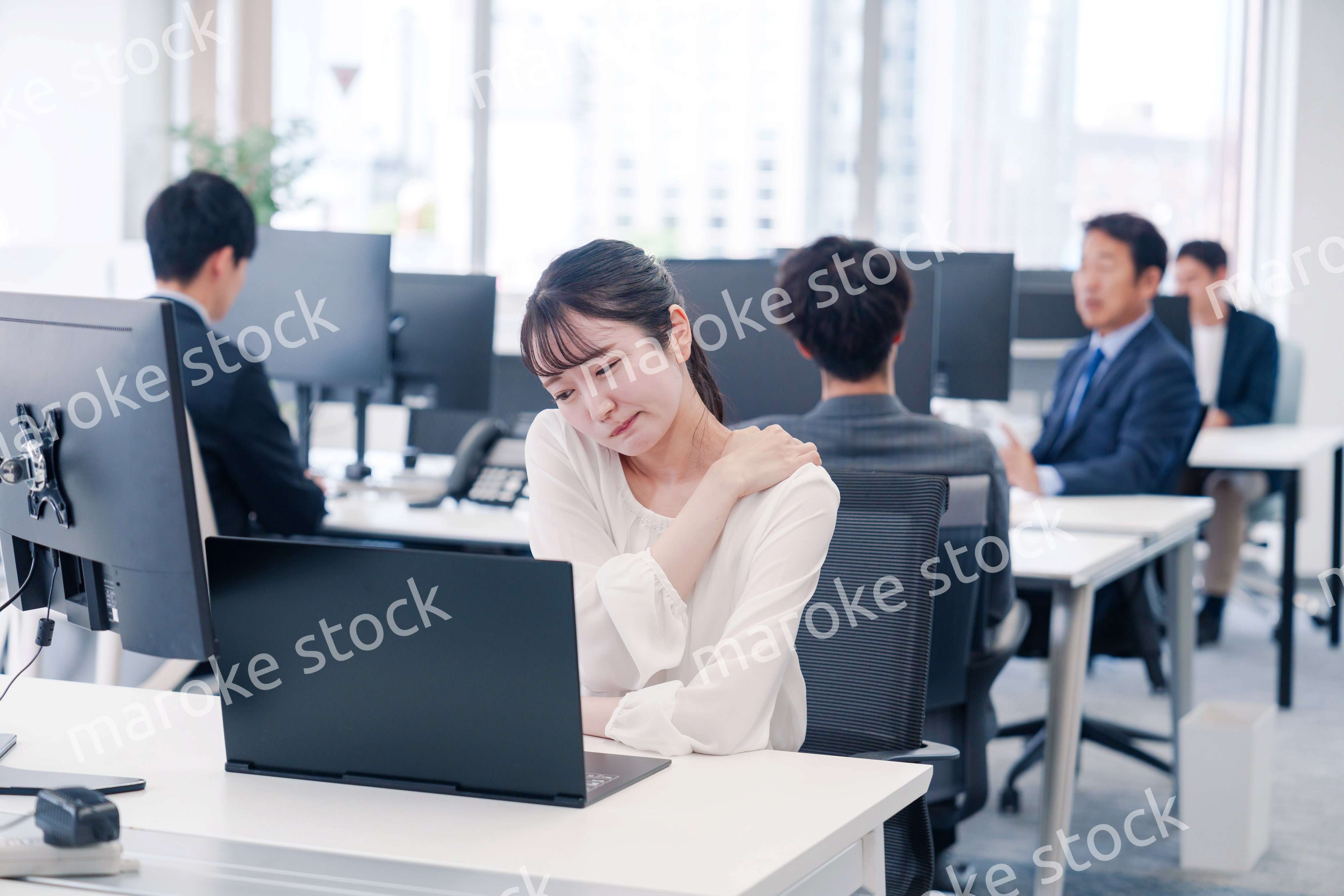 長時間のデスクワークで疲れたビジネスウーマン