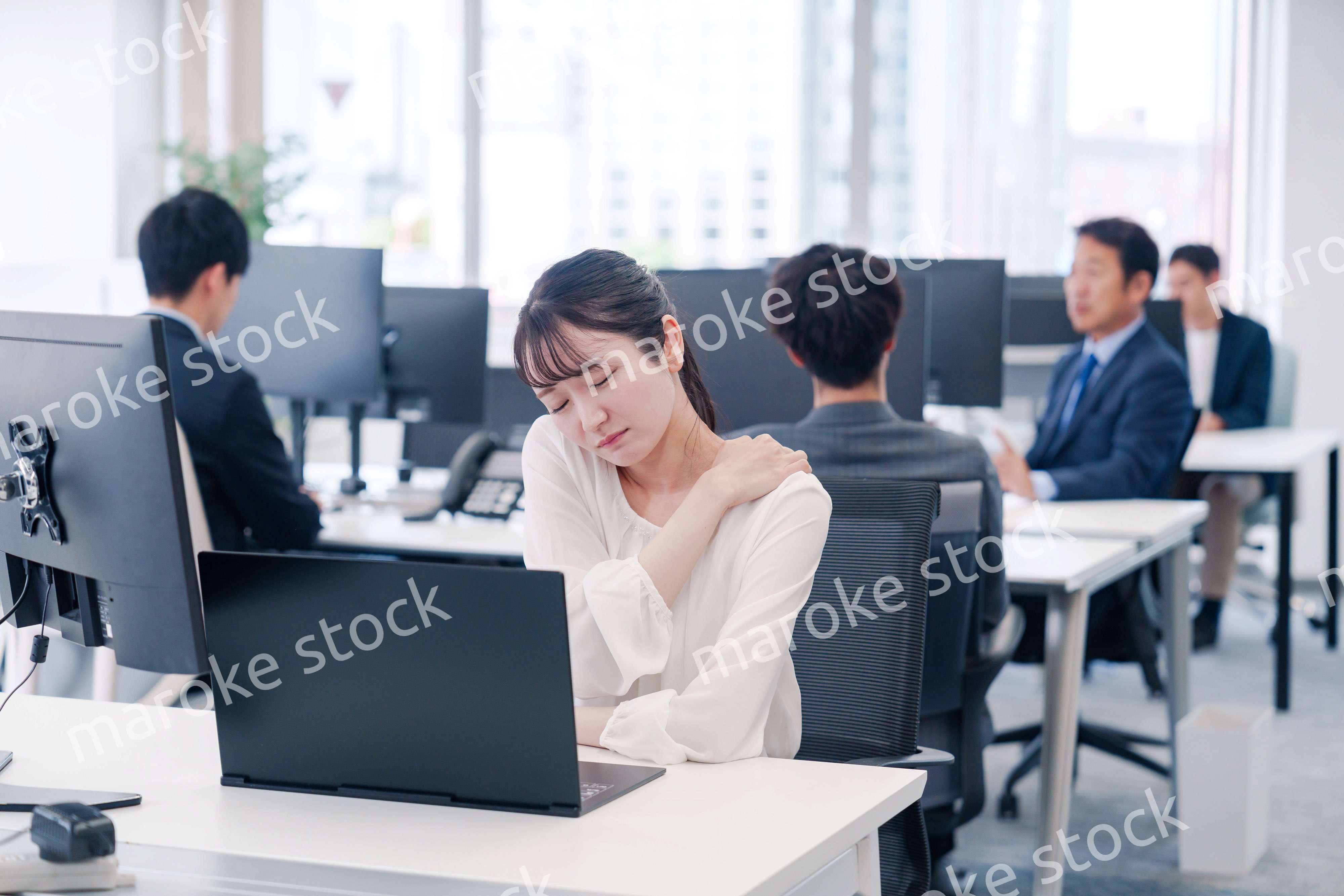 長時間のデスクワークで疲れたビジネスウーマン