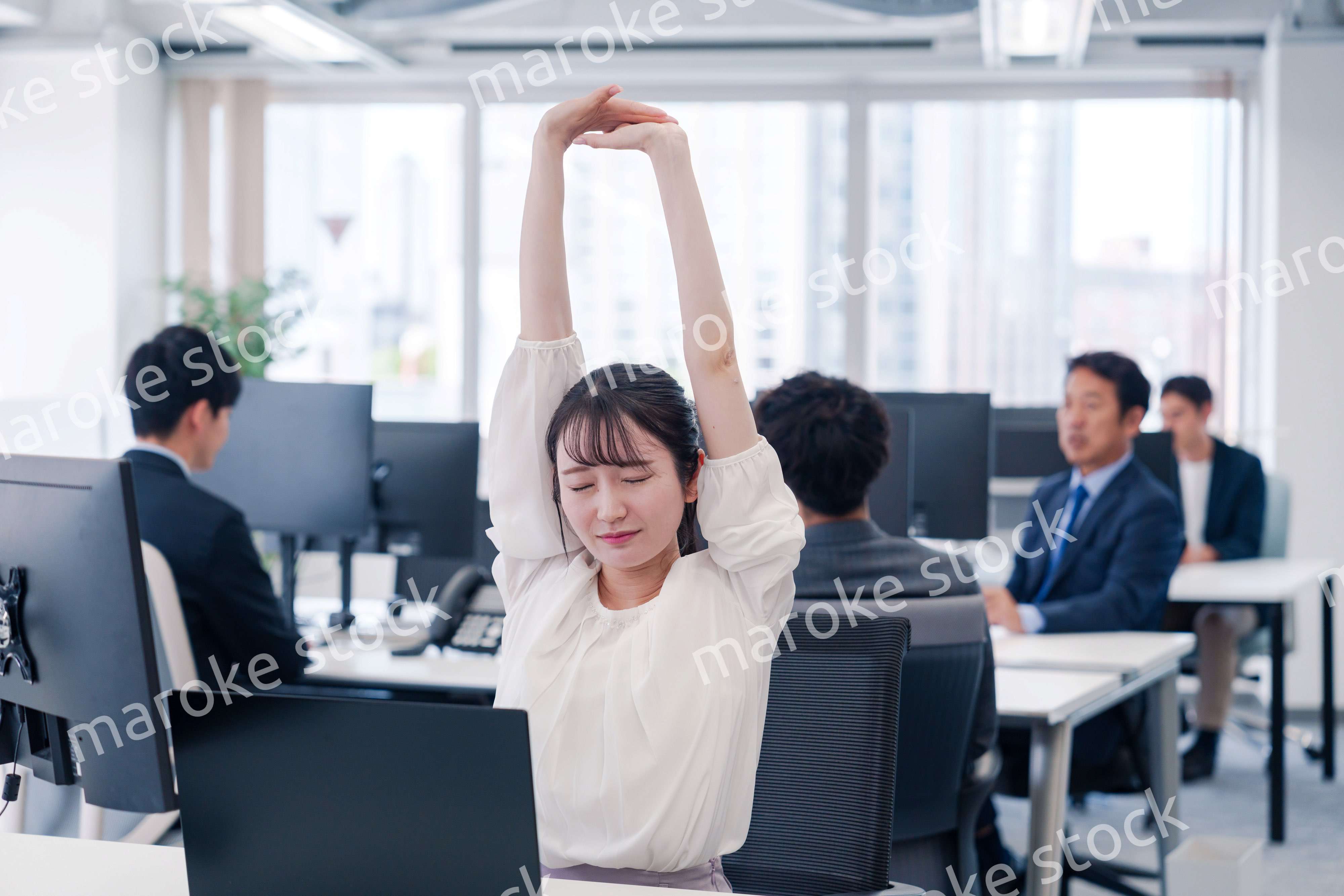 長時間のデスクワークで疲れたビジネスウーマン