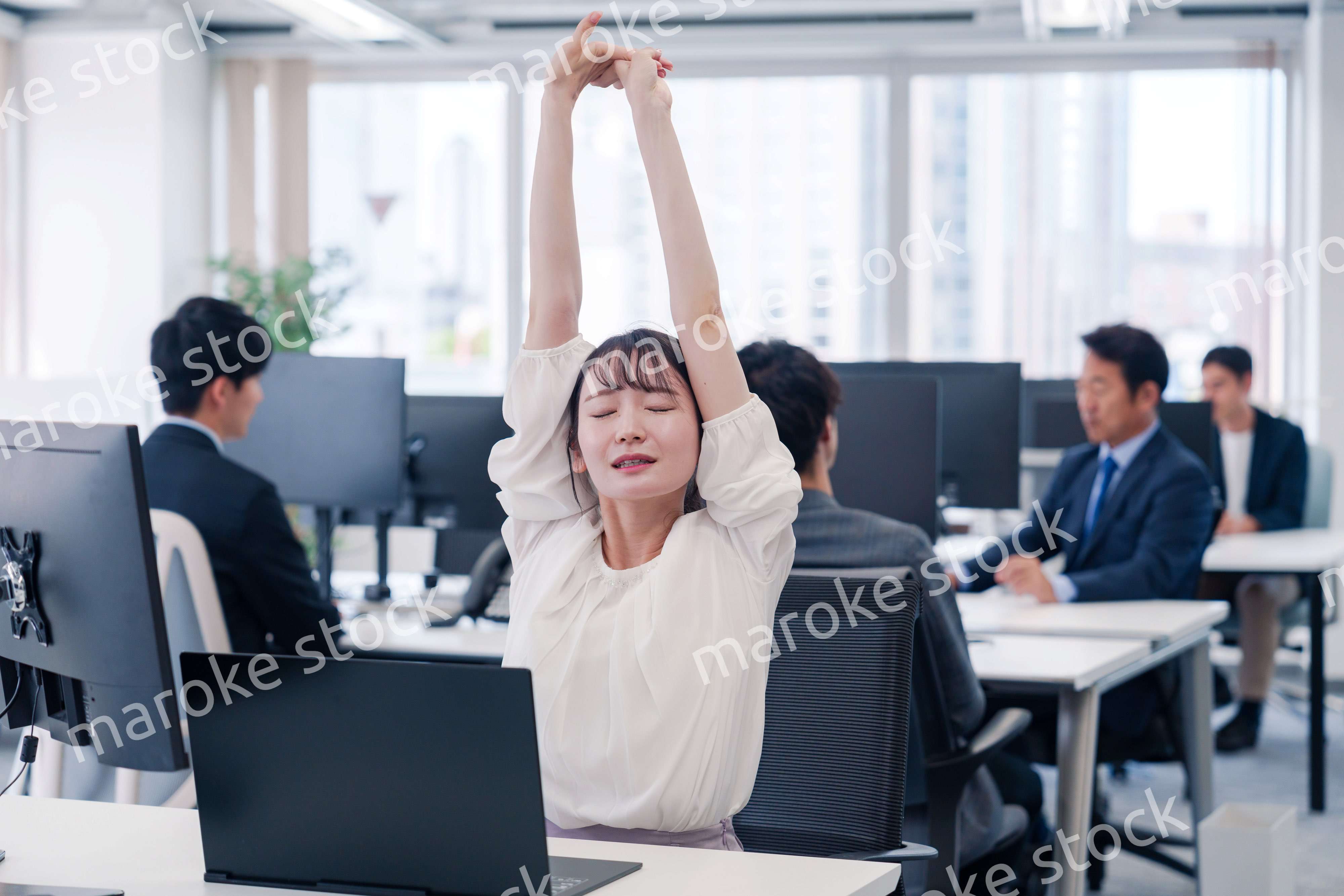 長時間のデスクワークで疲れたビジネスウーマン