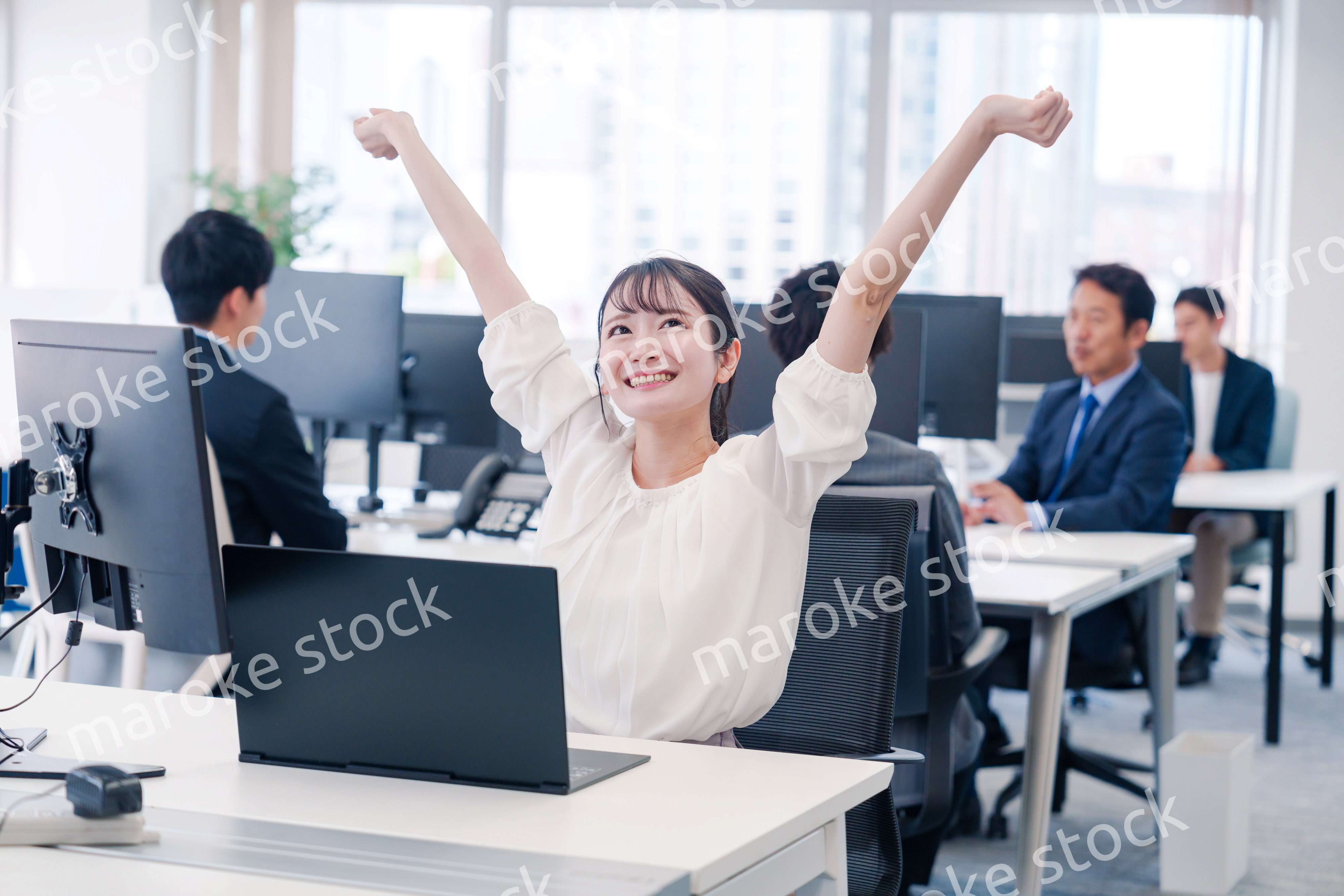 オフィスで伸びをしてリフレッシュするビジネスウーマン