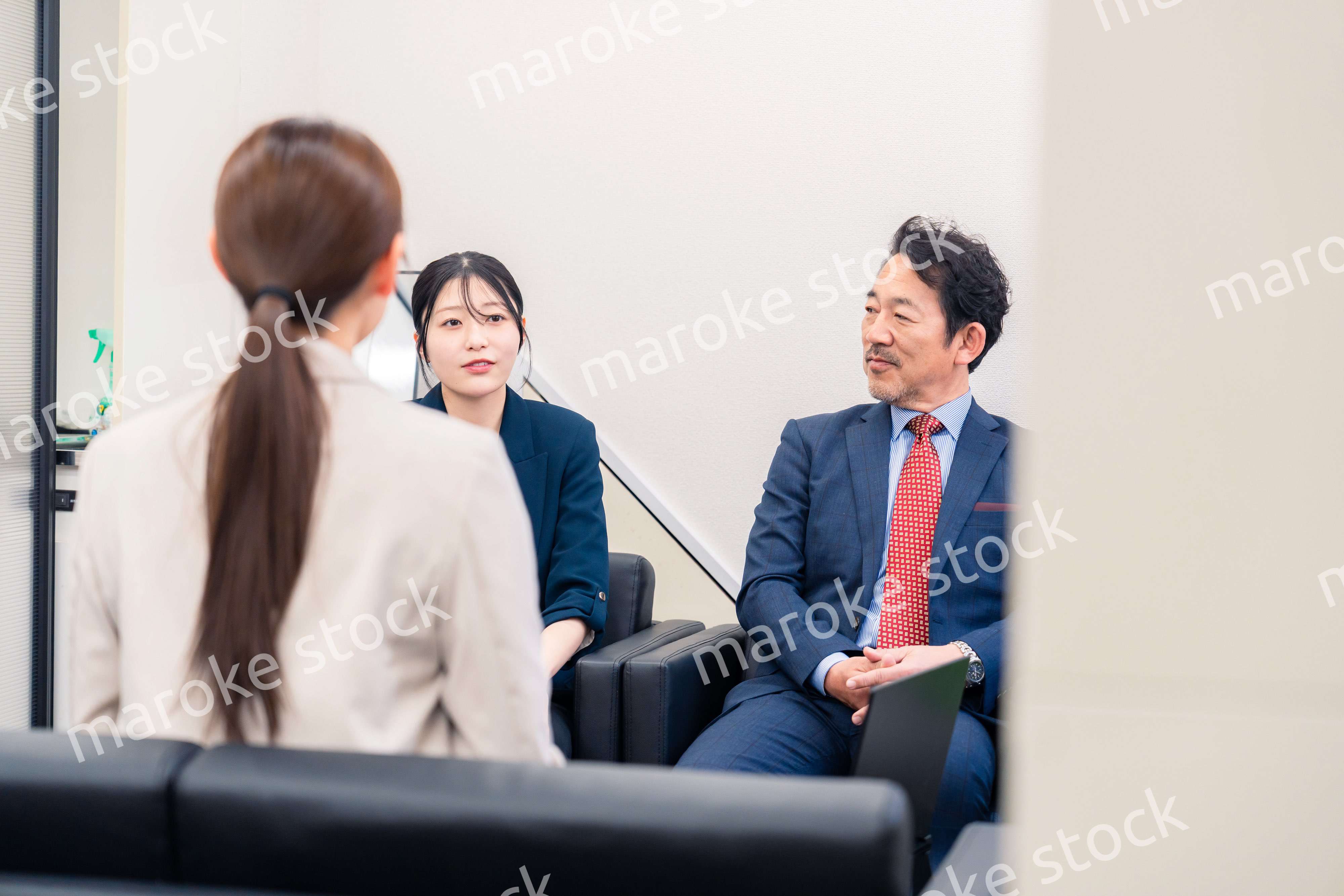 オフィスで楽しく会話をする中年男性とビジネスウーマン