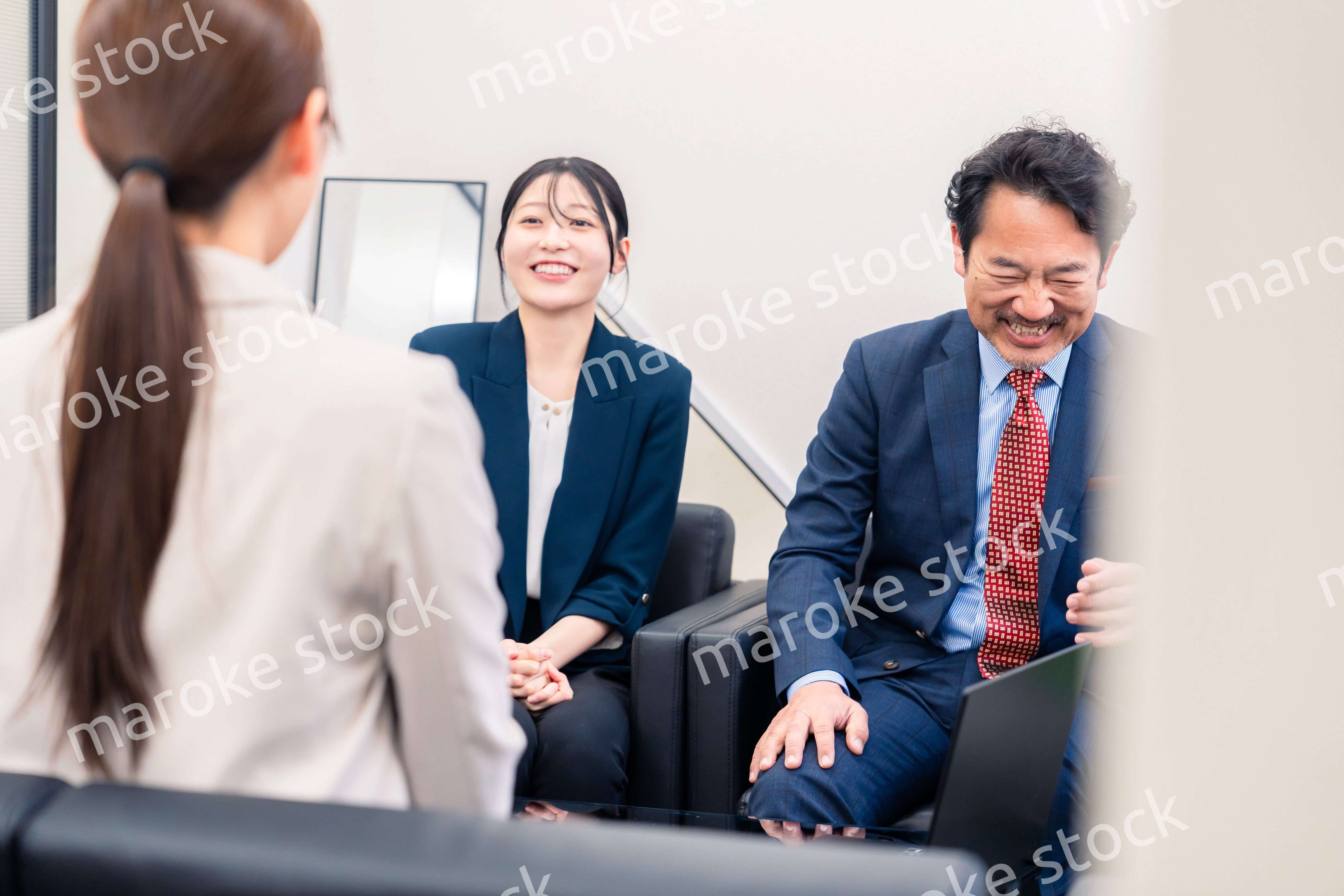 オフィスで楽しく会話をする中年男性とビジネスウーマン