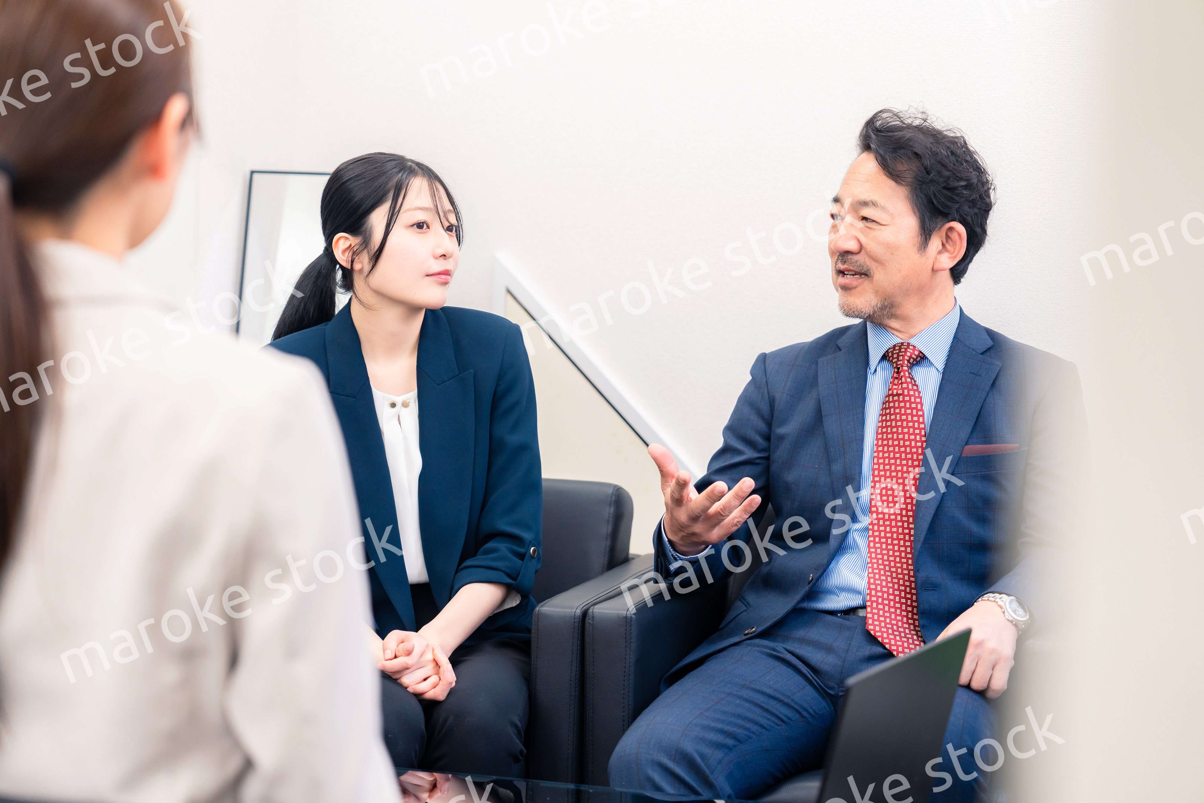 オフィスで楽しく会話をする中年男性とビジネスウーマン