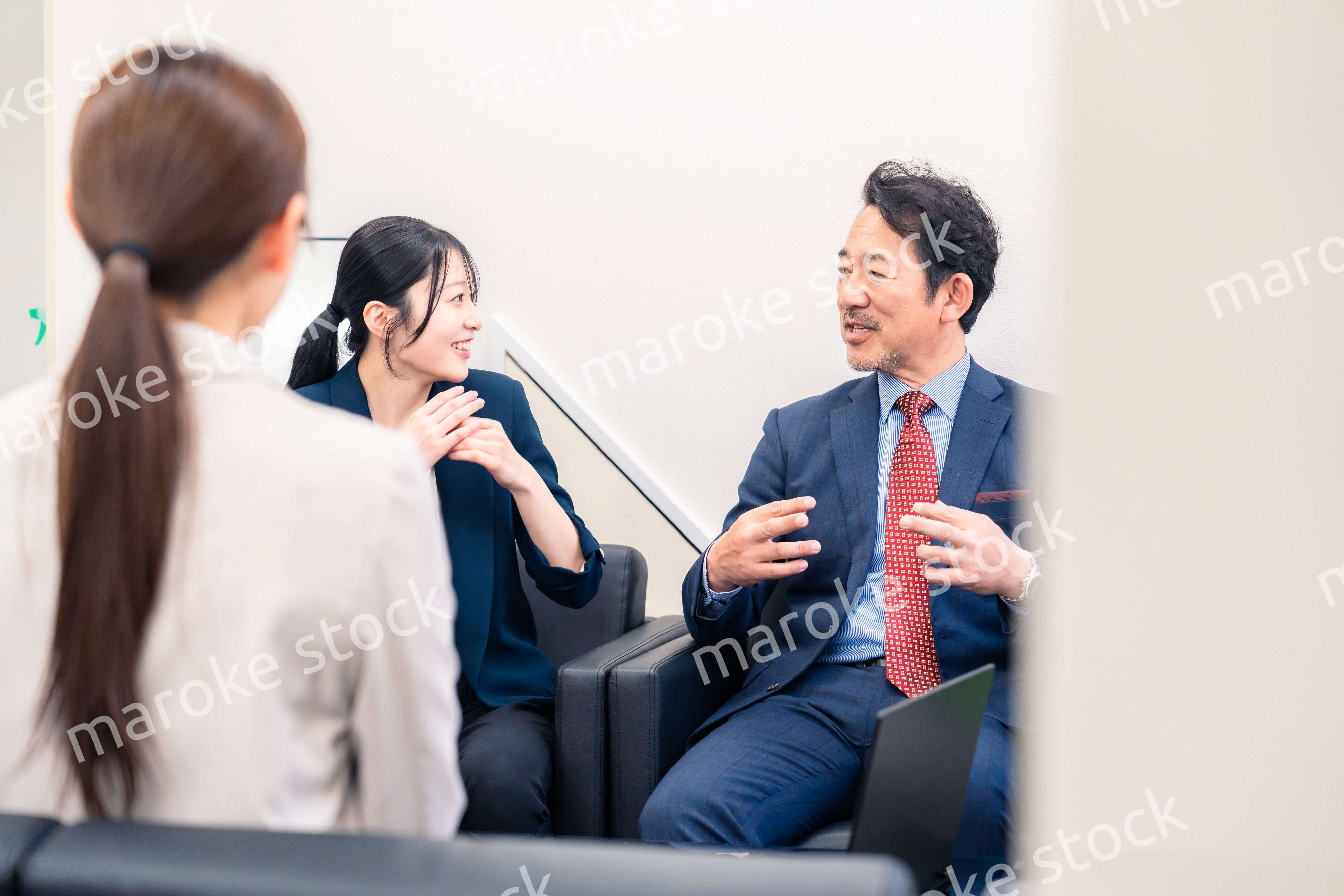 オフィスで楽しく会話をする中年男性とビジネスウーマン