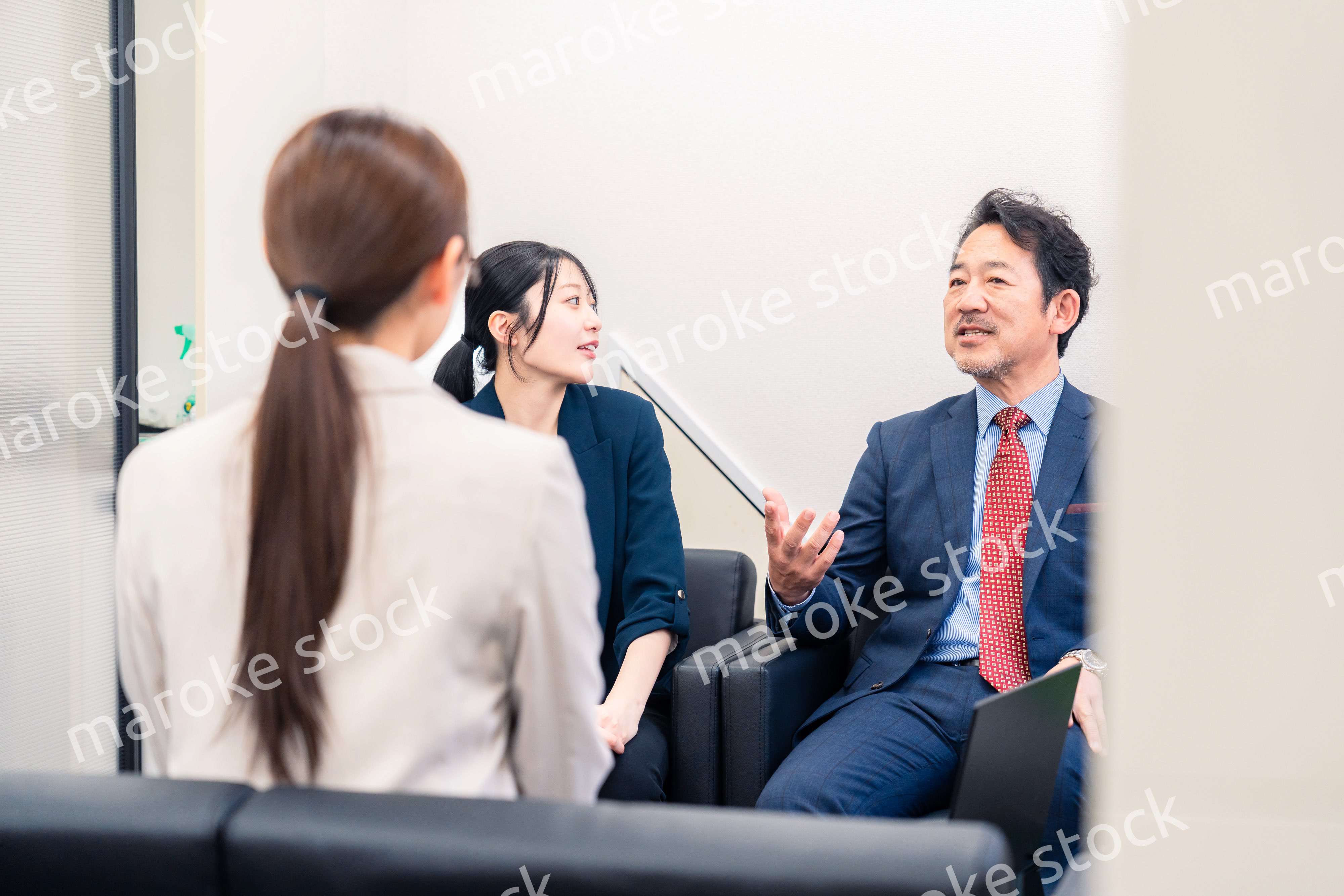 オフィスで楽しく会話をする中年男性とビジネスウーマン