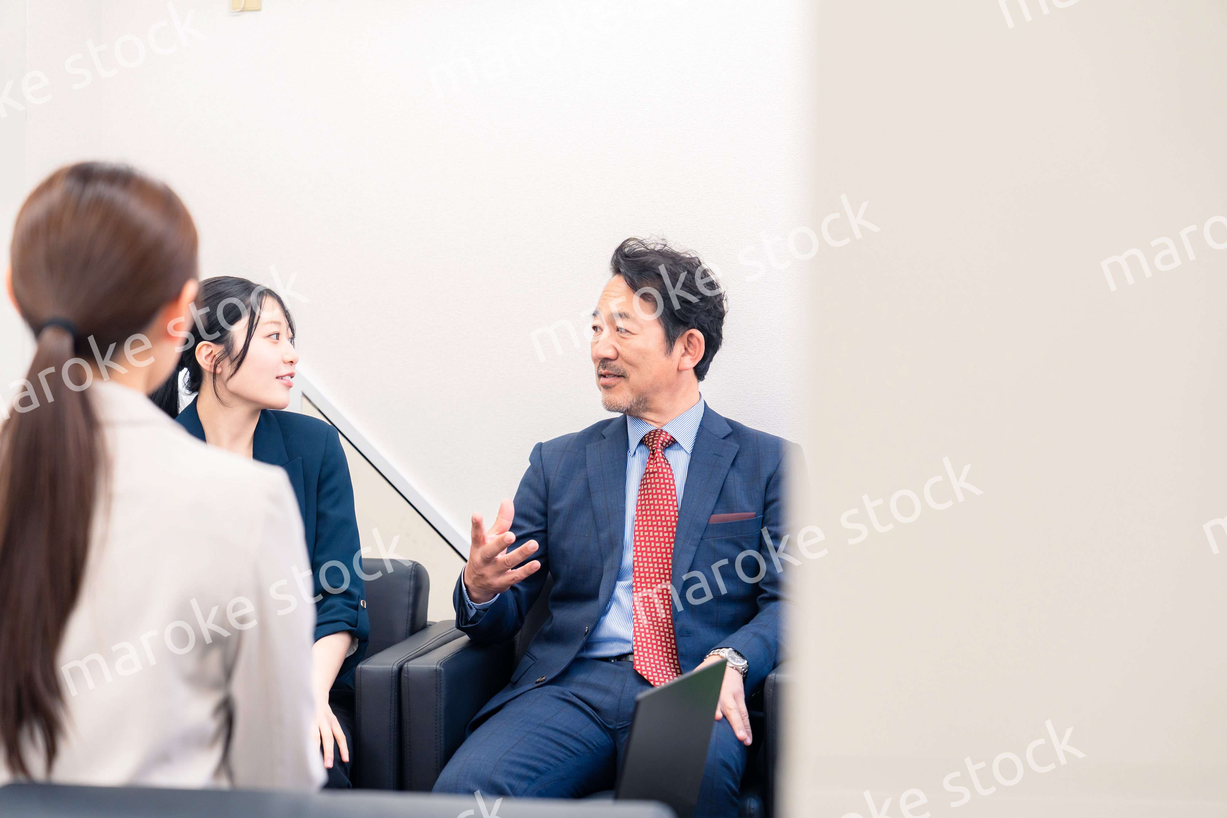 オフィスで楽しく会話をする中年男性とビジネスウーマン