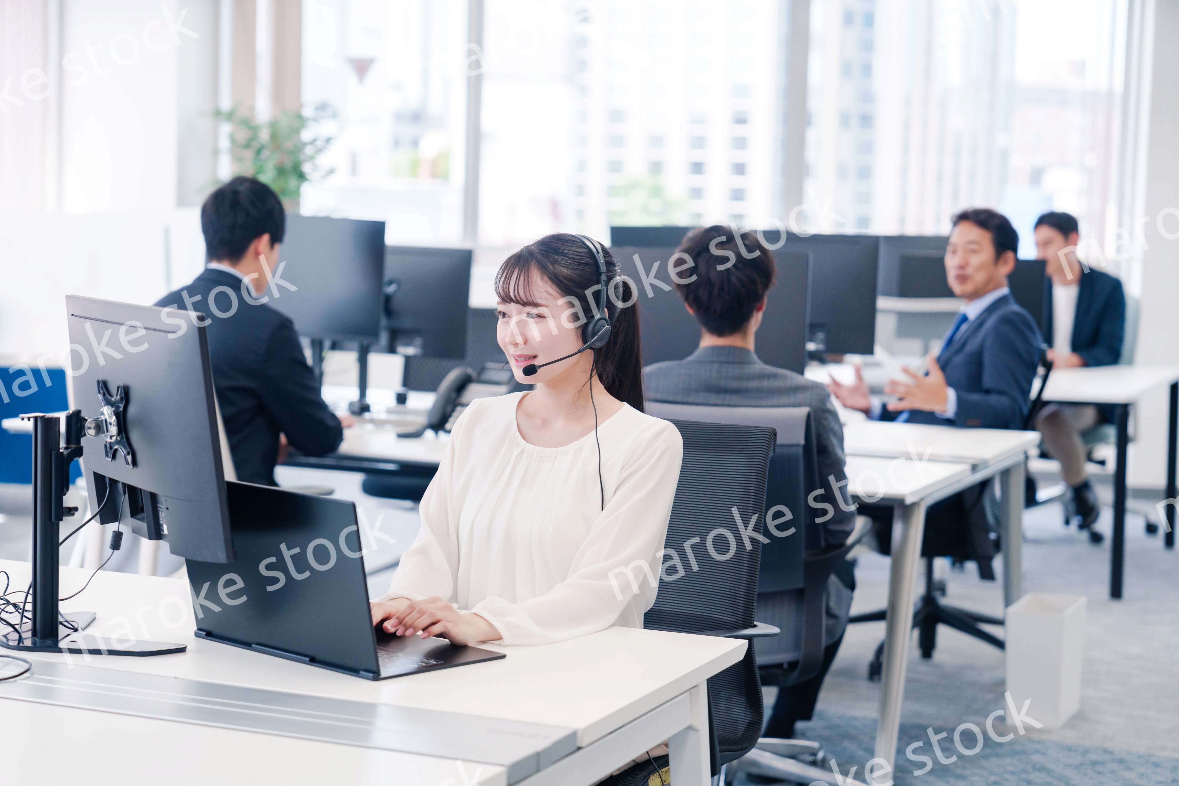 ヘッドセットをつけて話す若いビジネスウーマン