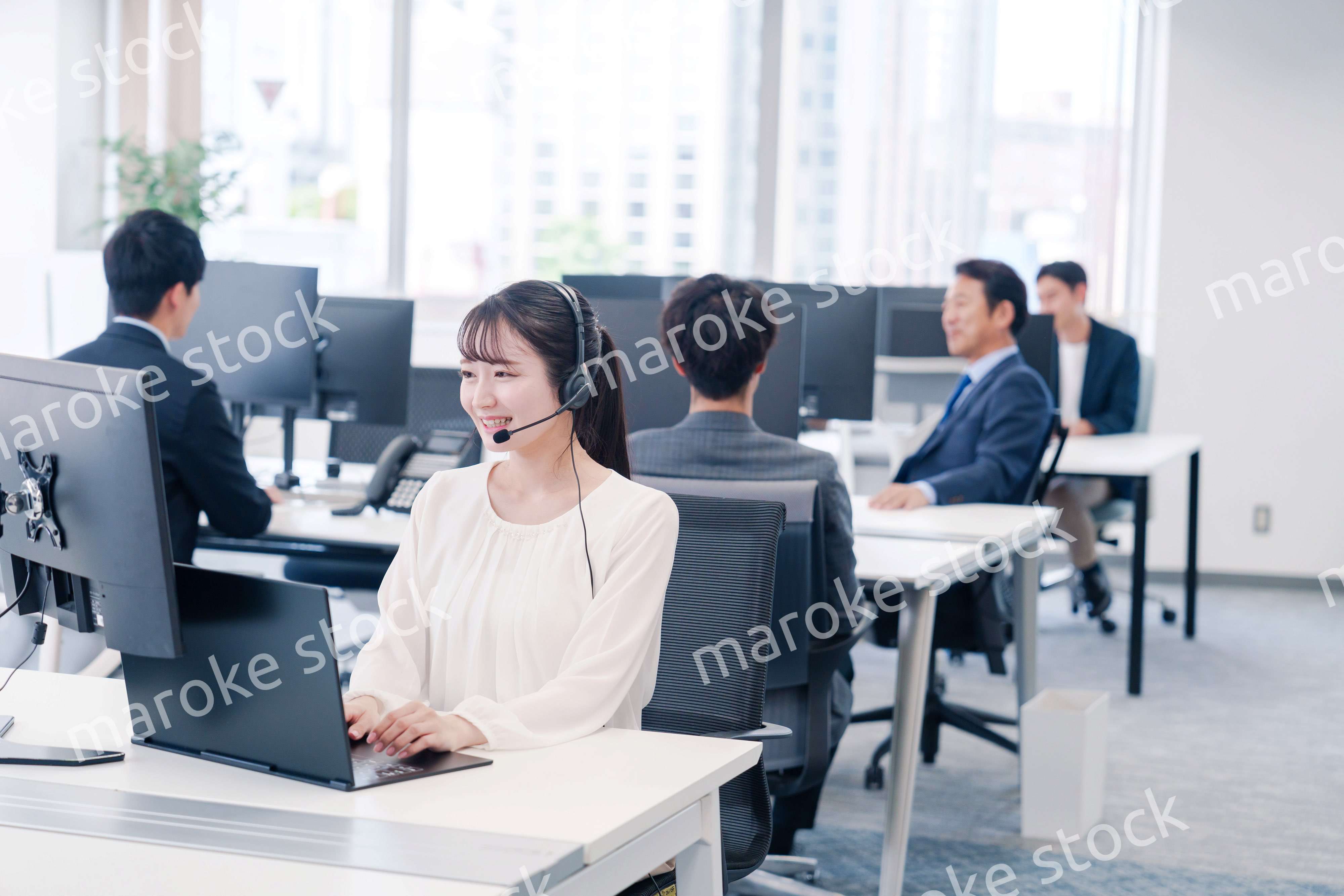 ヘッドセットをつけて話す若いビジネスウーマン