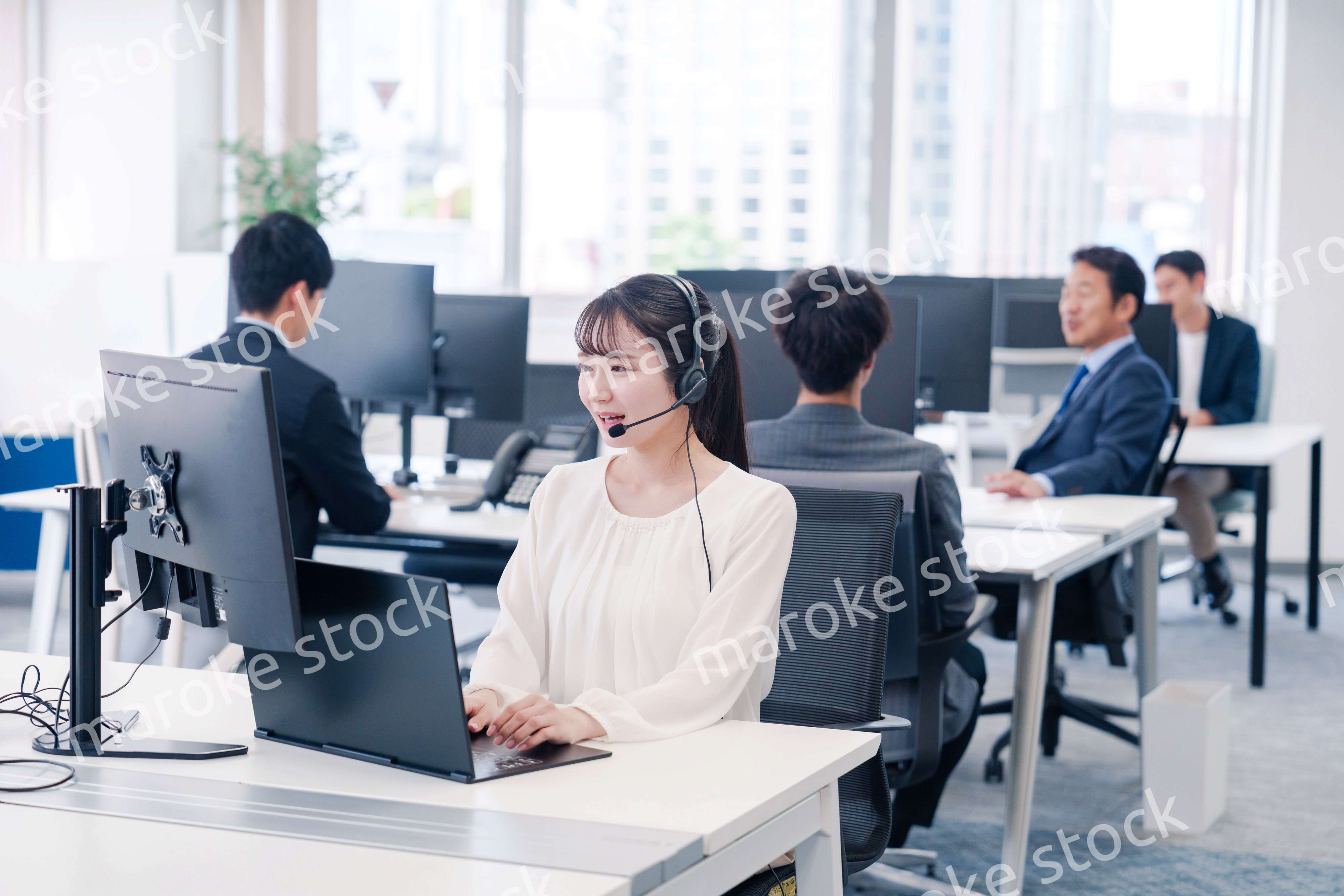 ヘッドセットをつけて話す若いビジネスウーマン