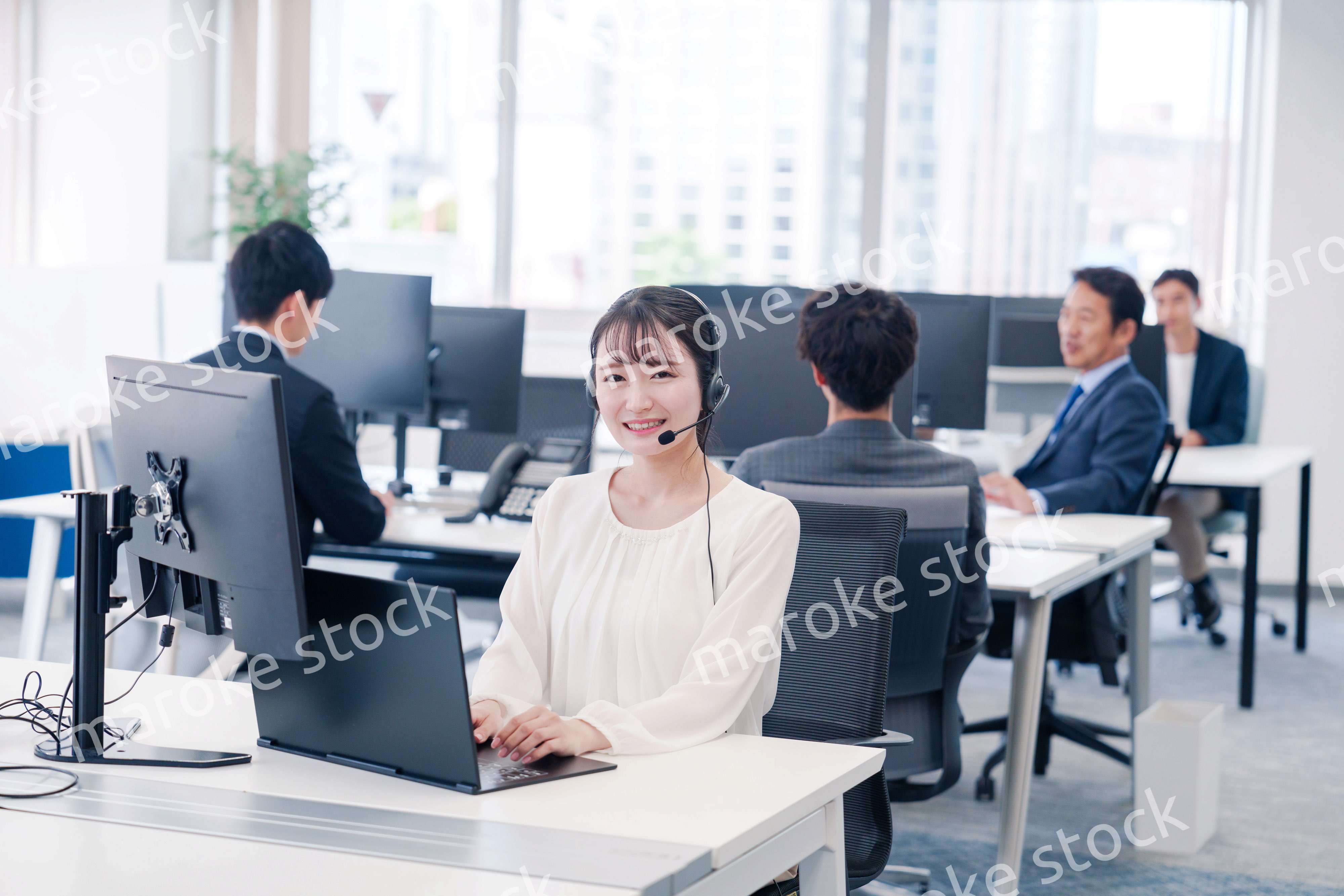 ヘッドセットをつけて話す若いビジネスウーマン