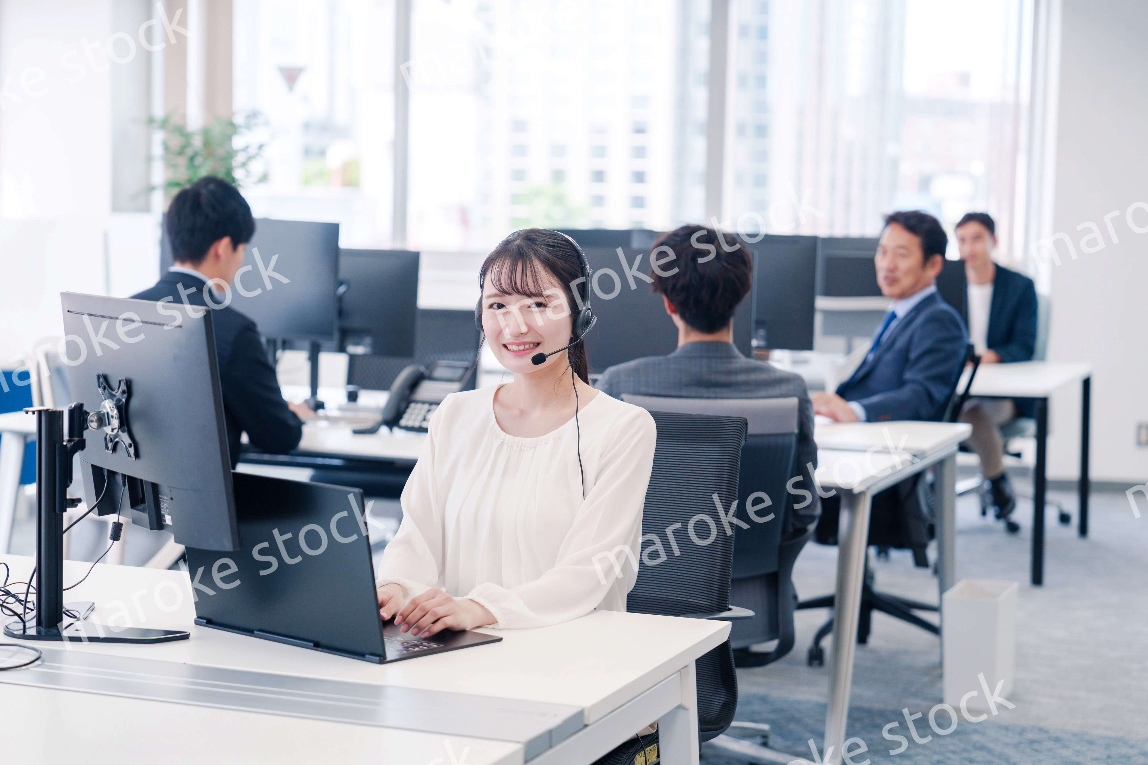 ヘッドセットをつけて話す若いビジネスウーマン