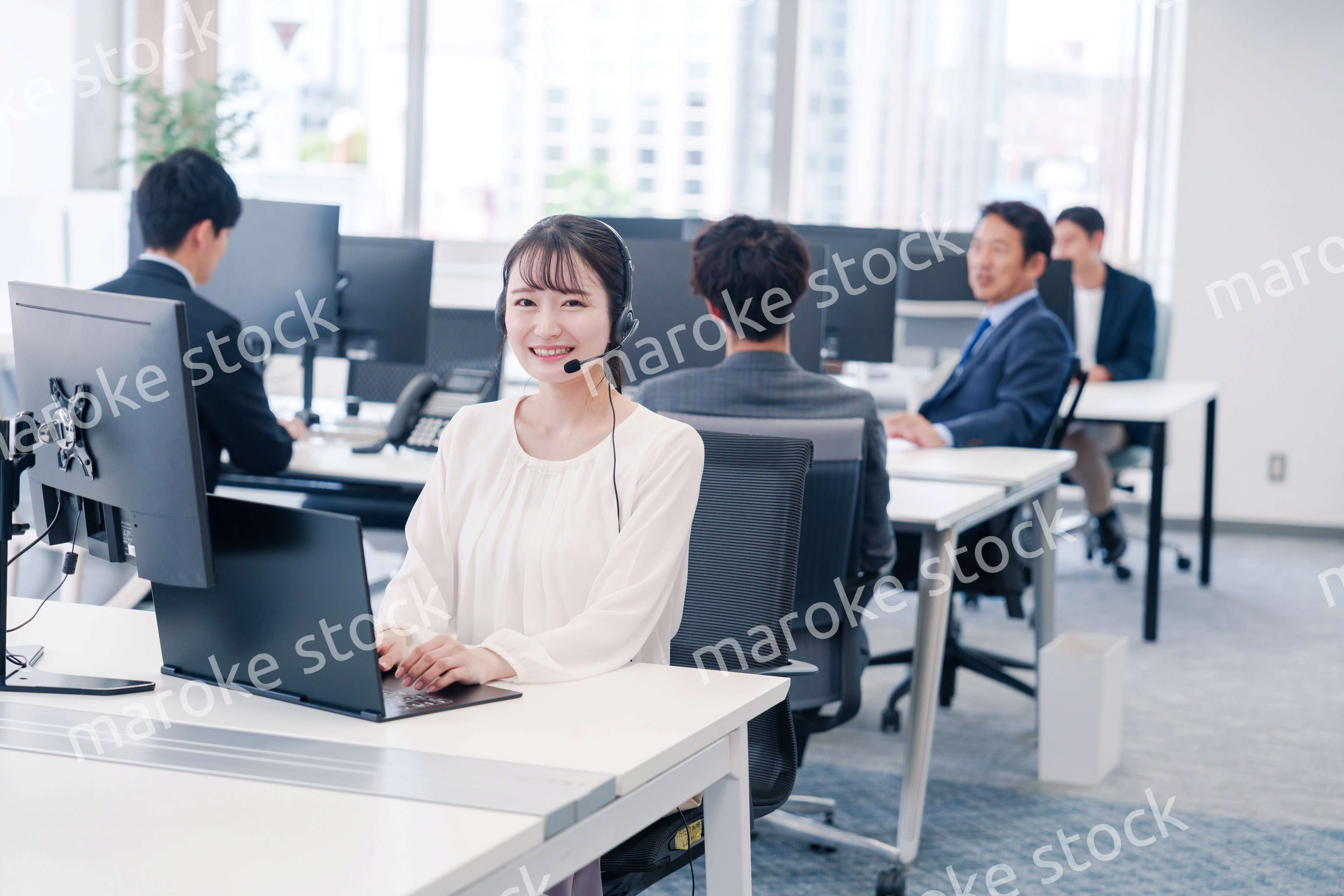 ヘッドセットをつけて話す若いビジネスウーマン