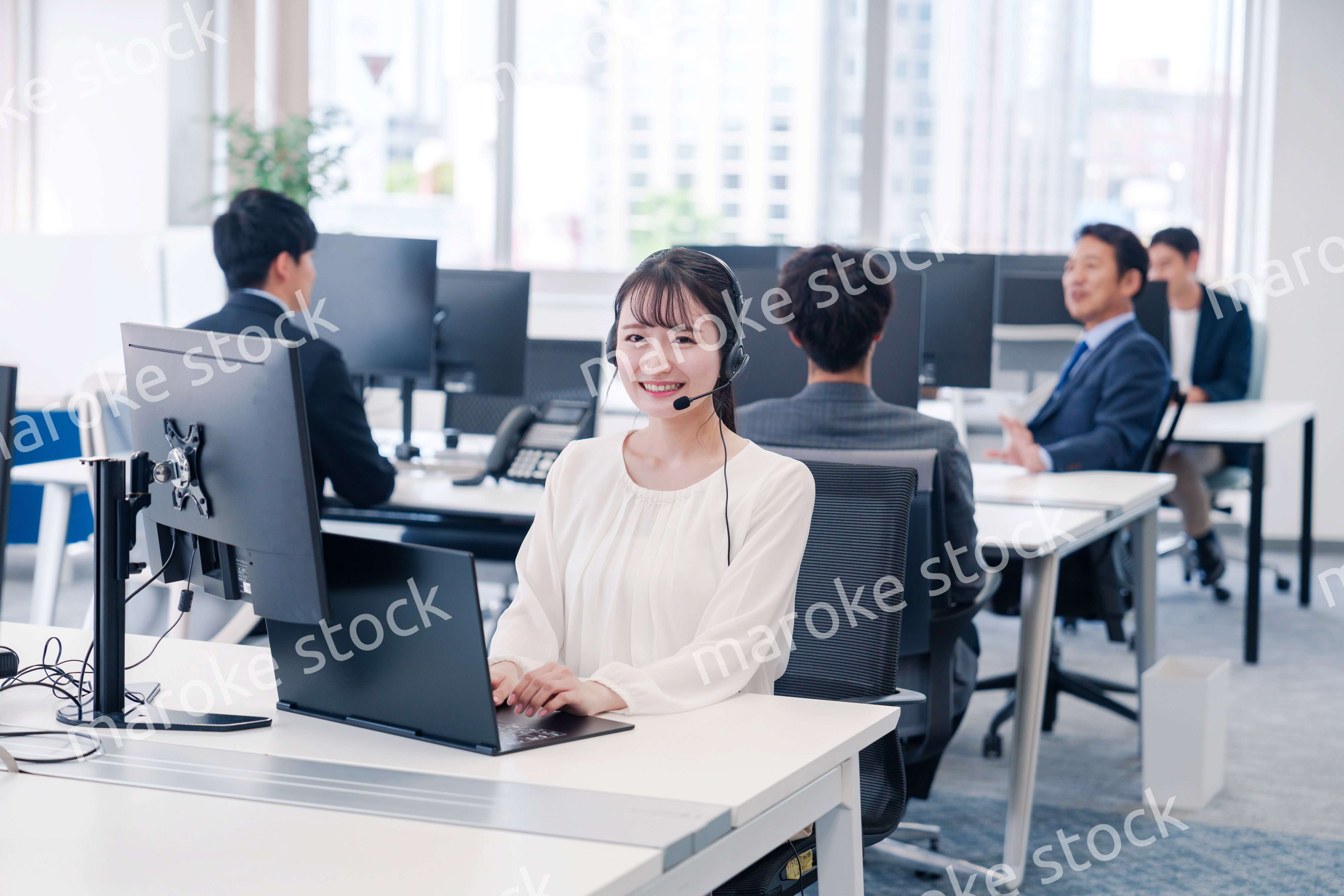 ヘッドセットをつけて話す若いビジネスウーマン