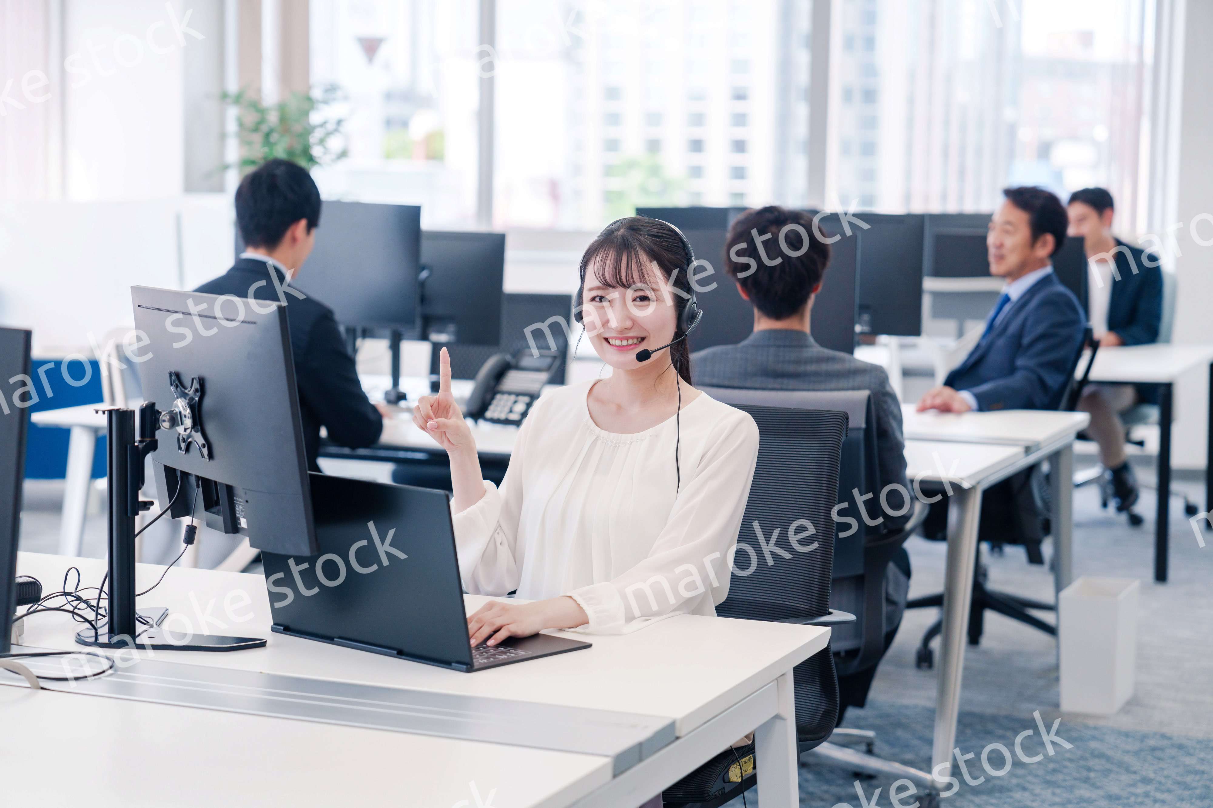 ヘッドセットをつけて話す若いビジネスウーマン