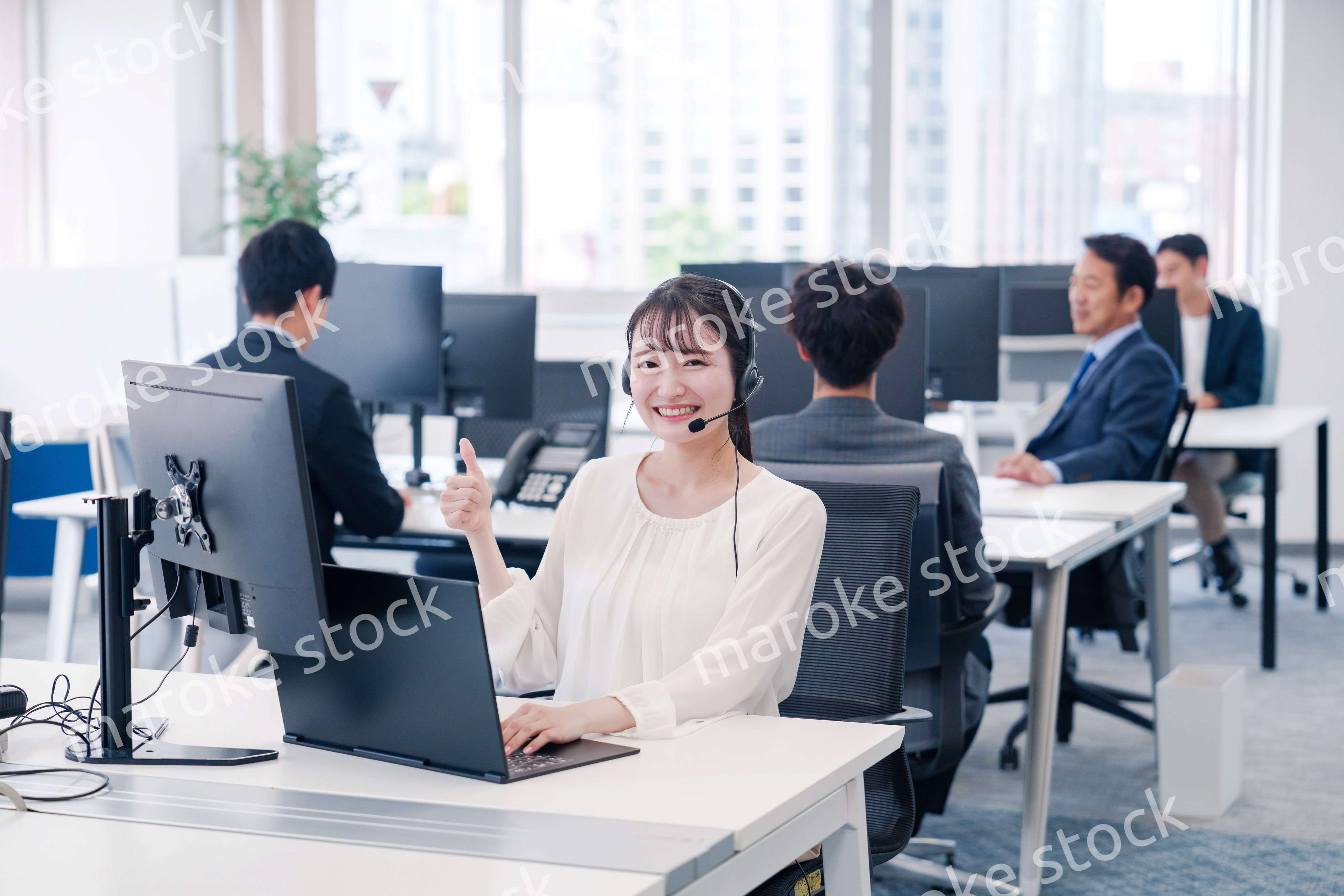 ヘッドセットをつけて話す若いビジネスウーマン