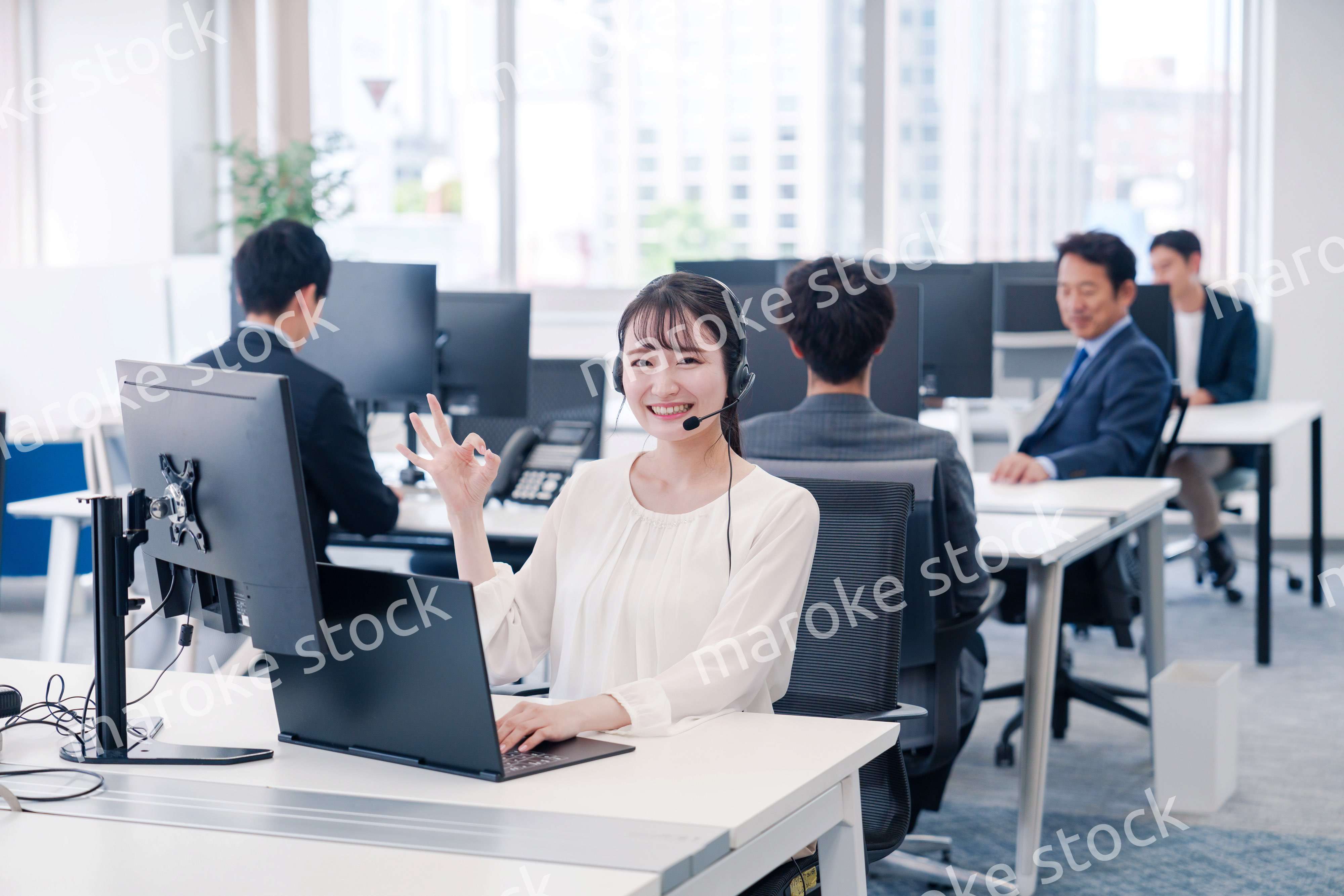 ヘッドセットをつけて話す若いビジネスウーマン