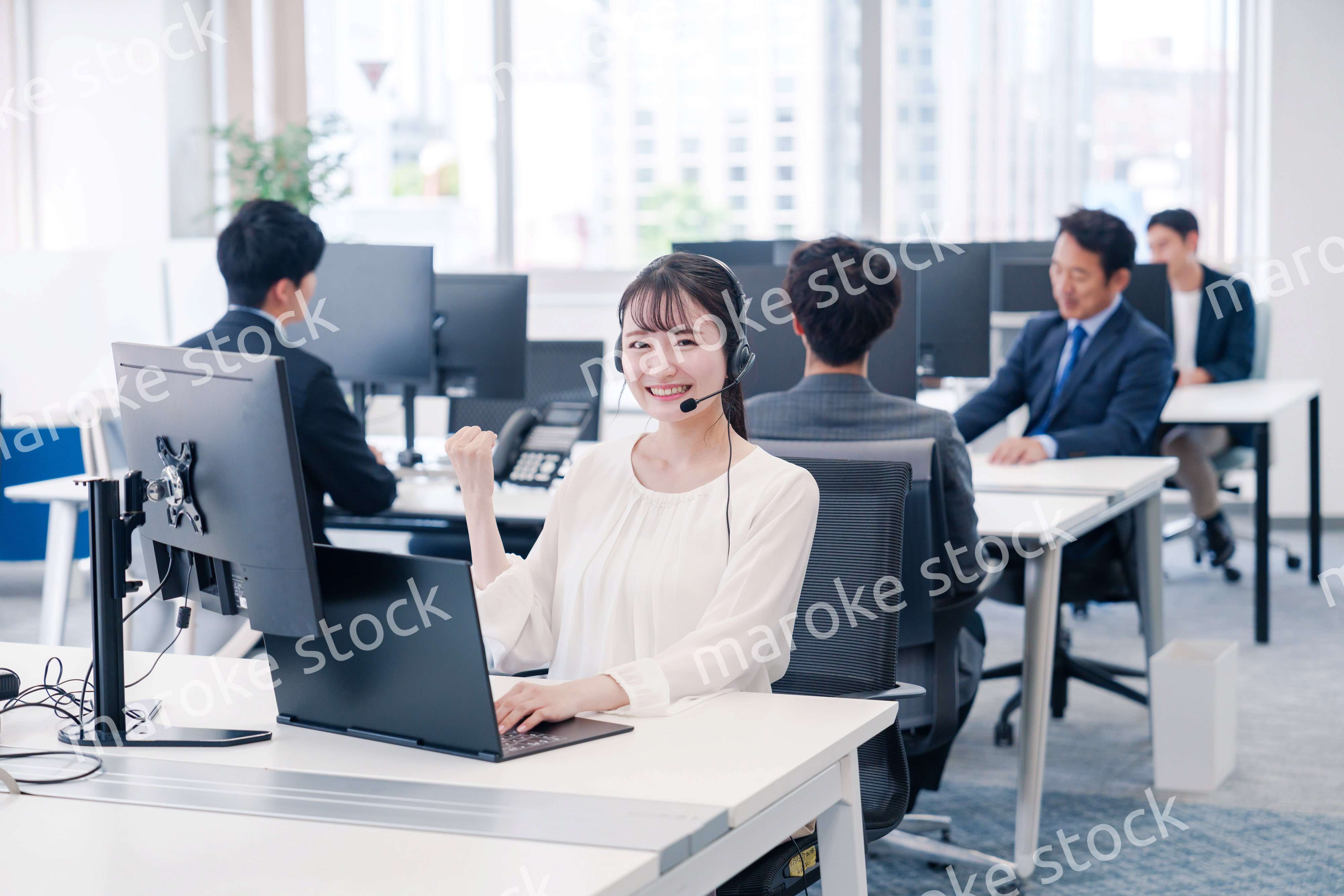 ヘッドセットをつけて話す若いビジネスウーマン