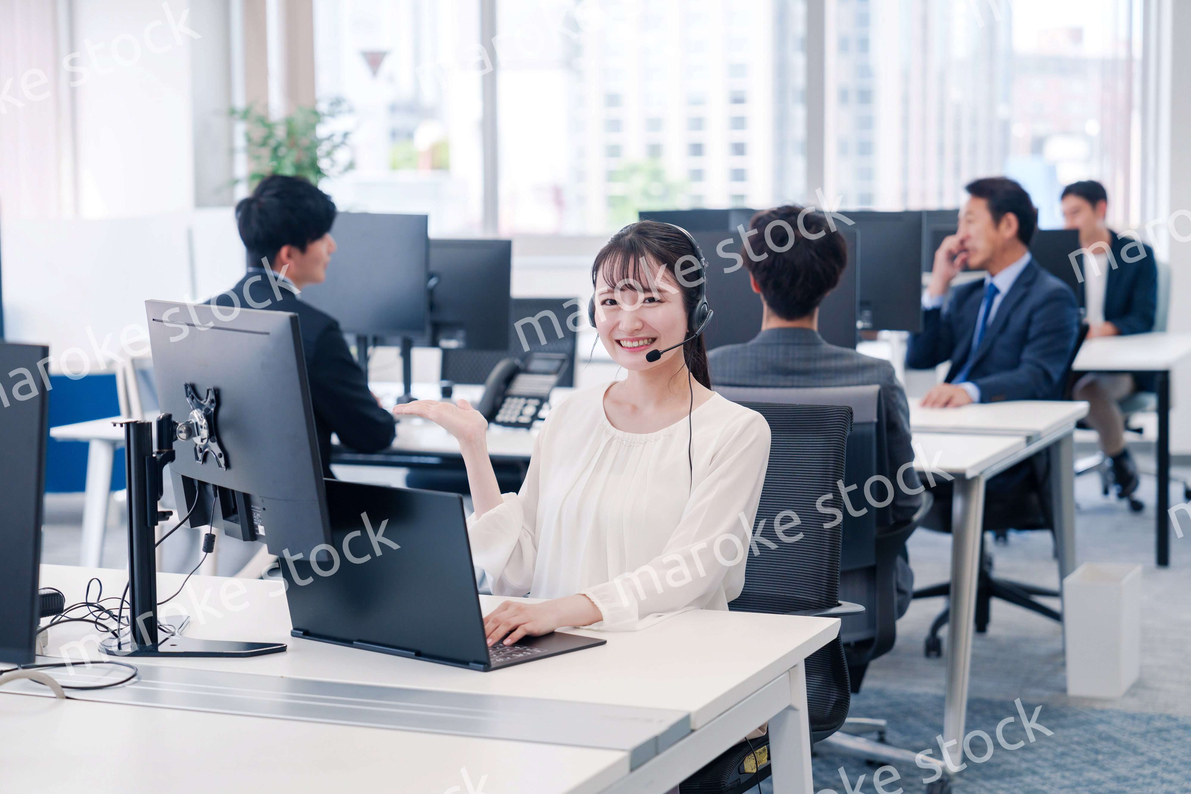 ヘッドセットをつけて話す若いビジネスウーマン