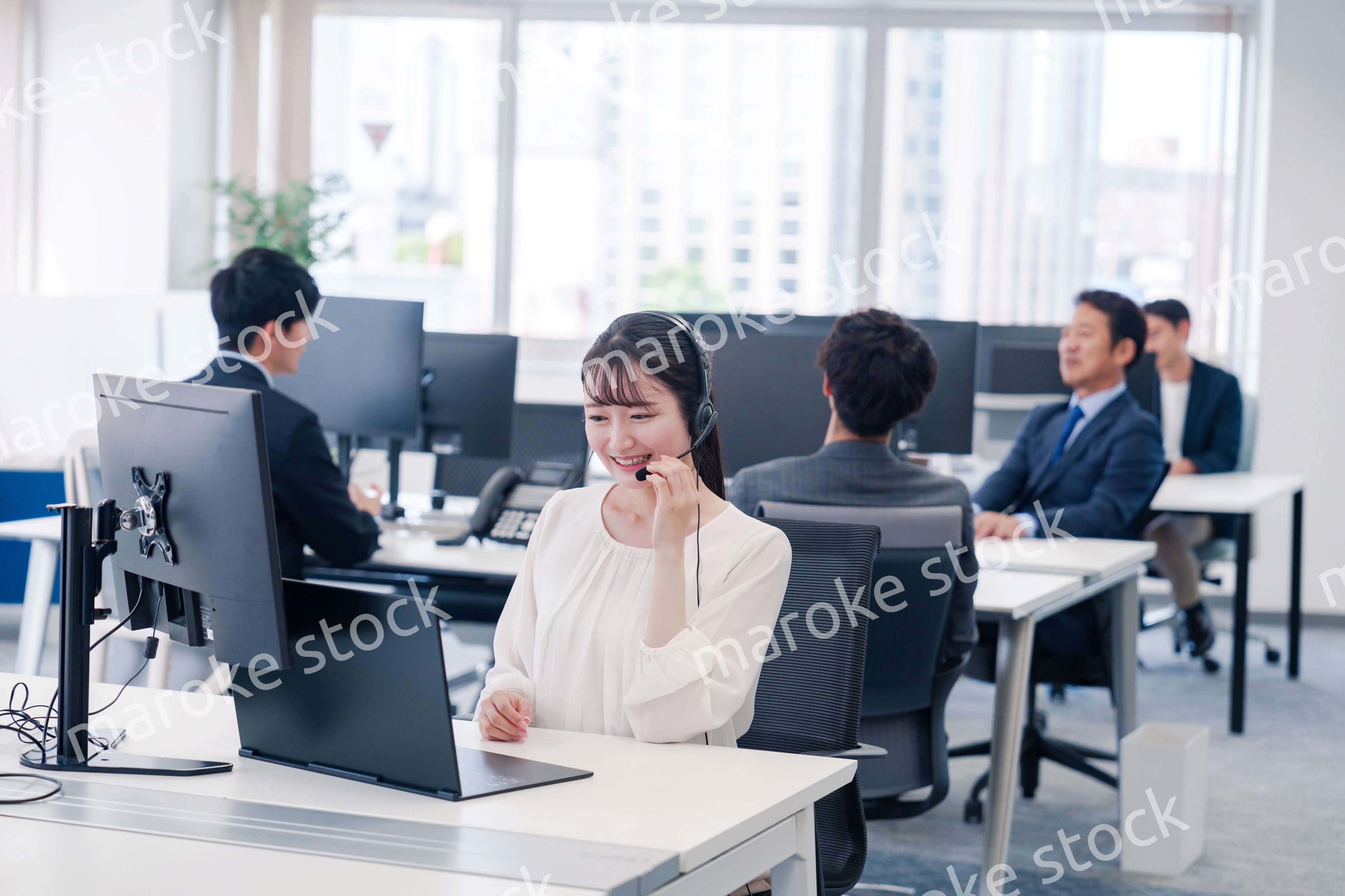 ヘッドセットをつけて話す若いビジネスウーマン