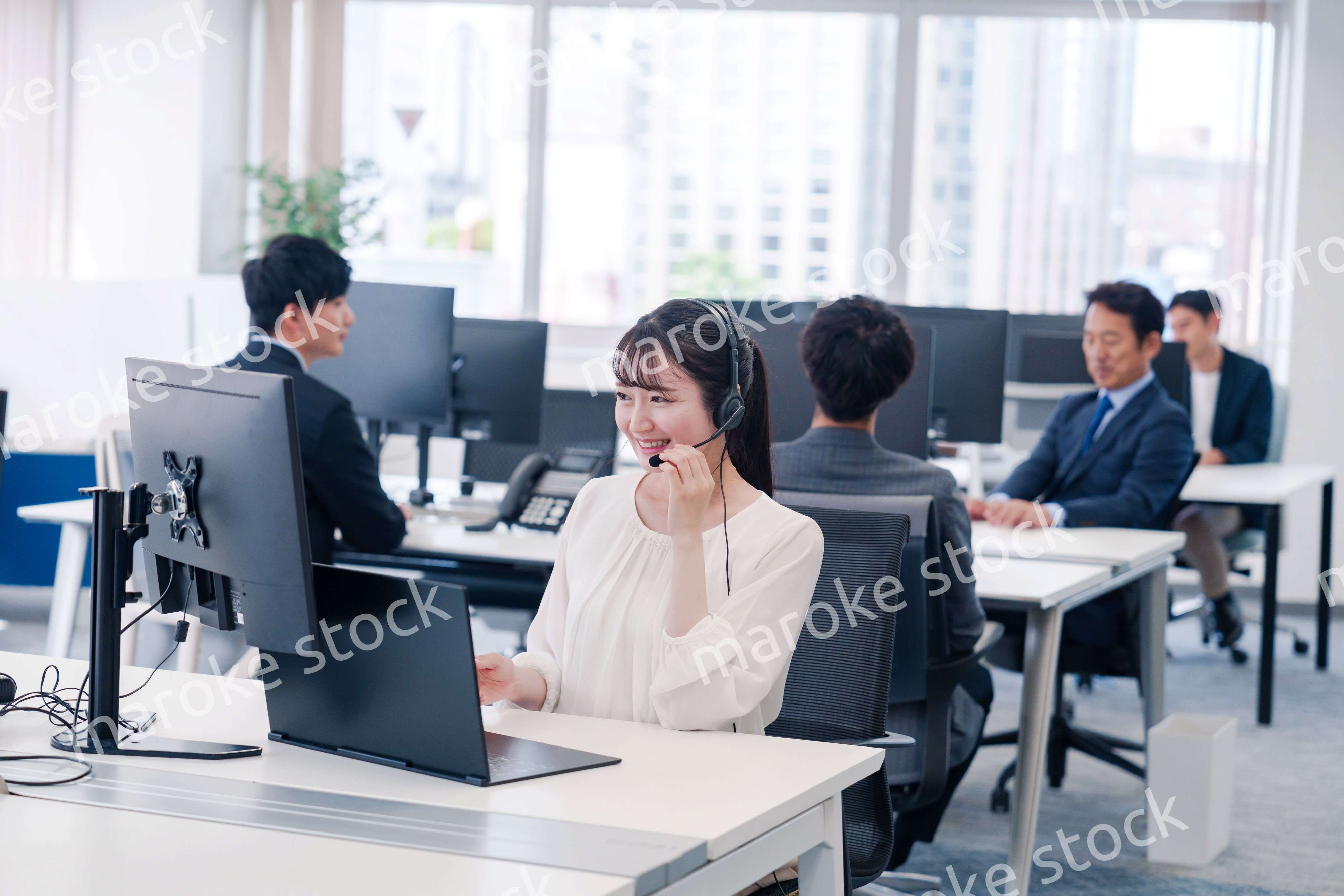 ヘッドセットをつけて話す若いビジネスウーマン