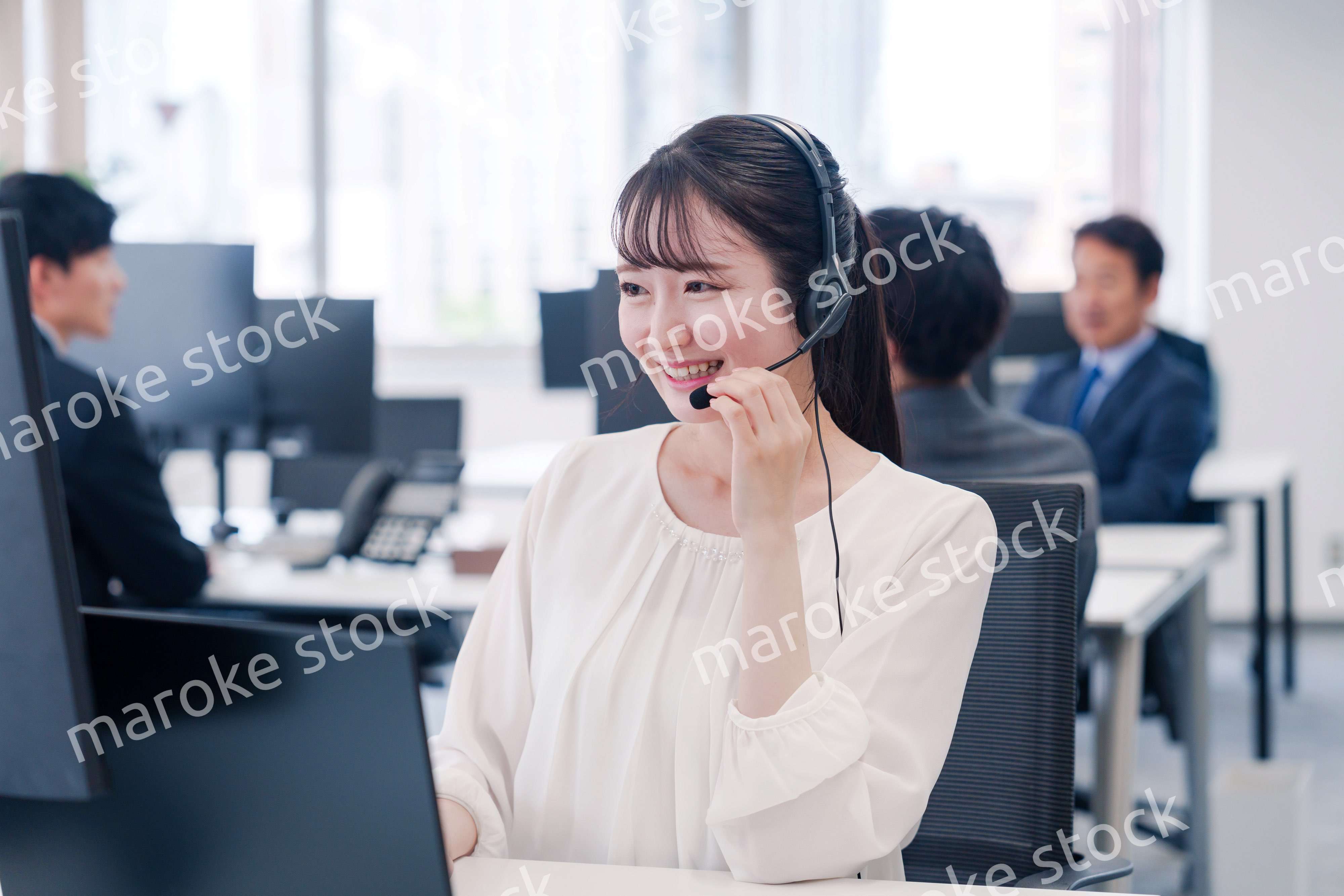 ヘッドセットをつけて話す若いビジネスウーマン