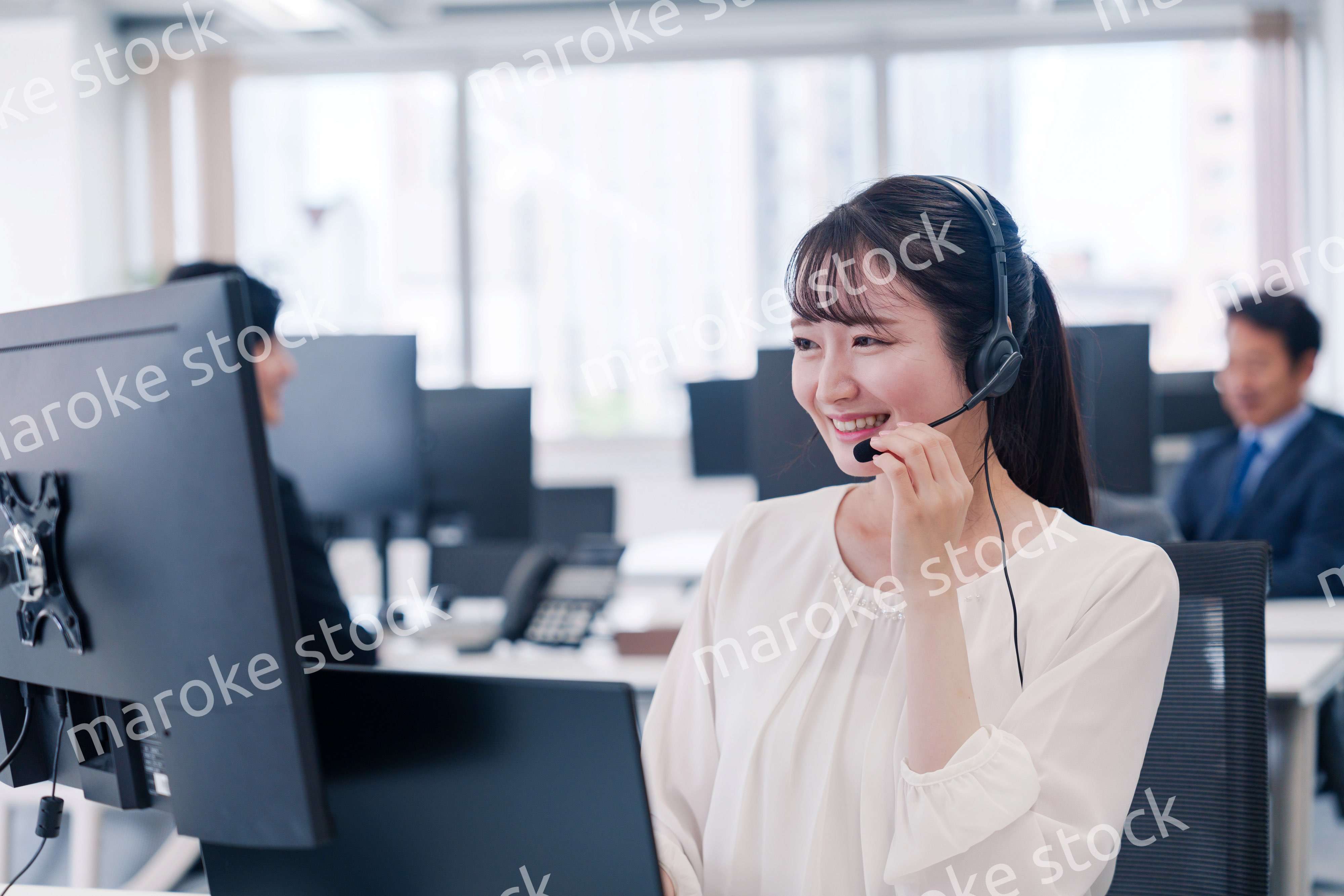 ヘッドセットをつけて話す若いビジネスウーマン