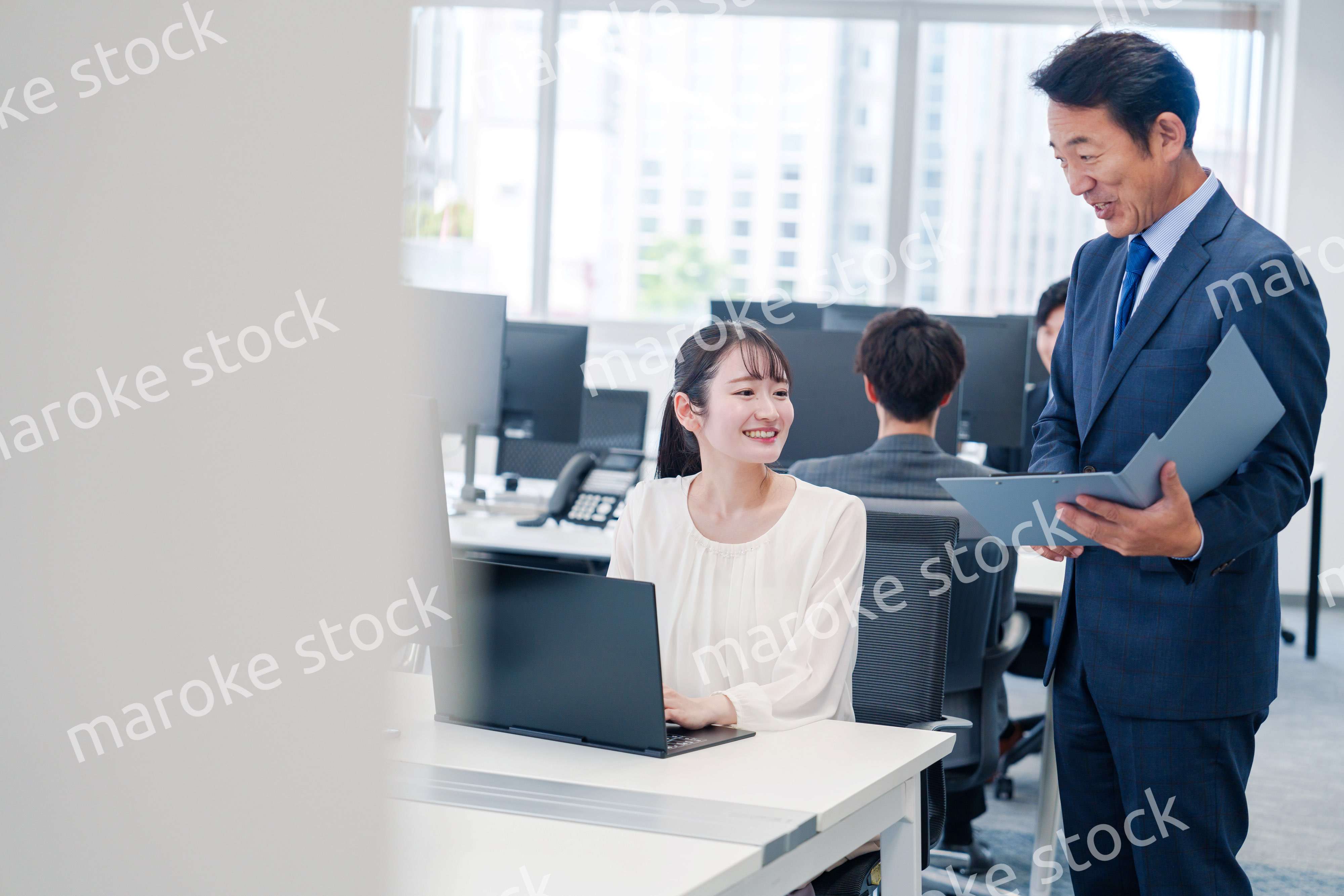 オフィスで上司と話をするビジネスウーマン