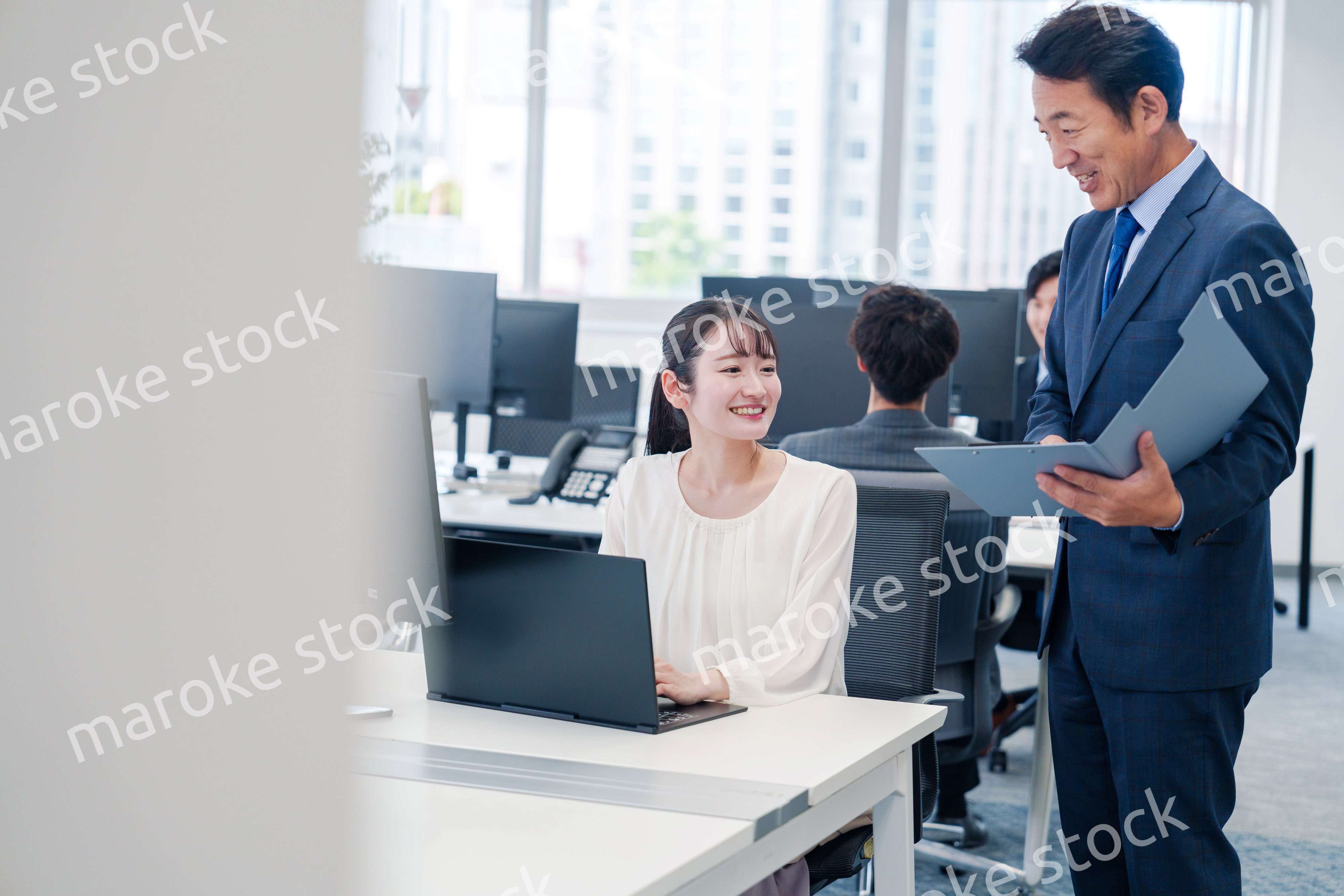 オフィスで上司と話をするビジネスウーマン