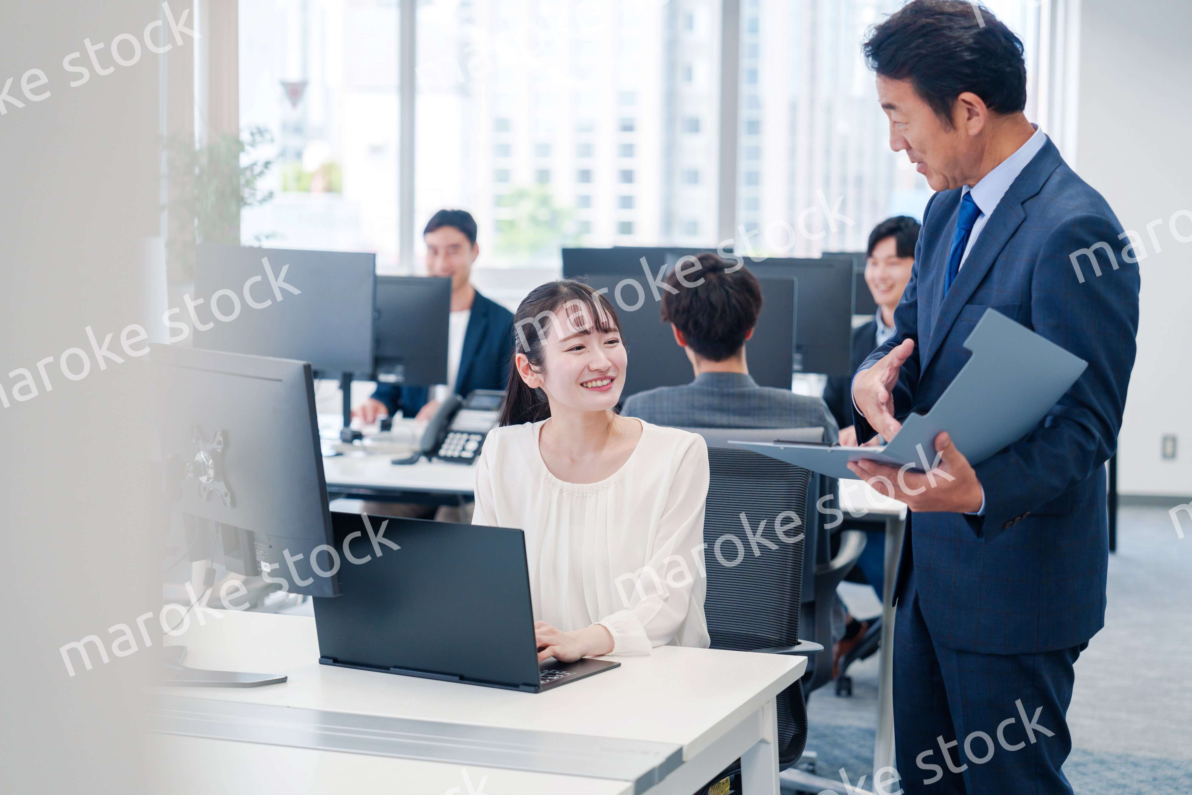 オフィスで上司と話をするビジネスウーマン