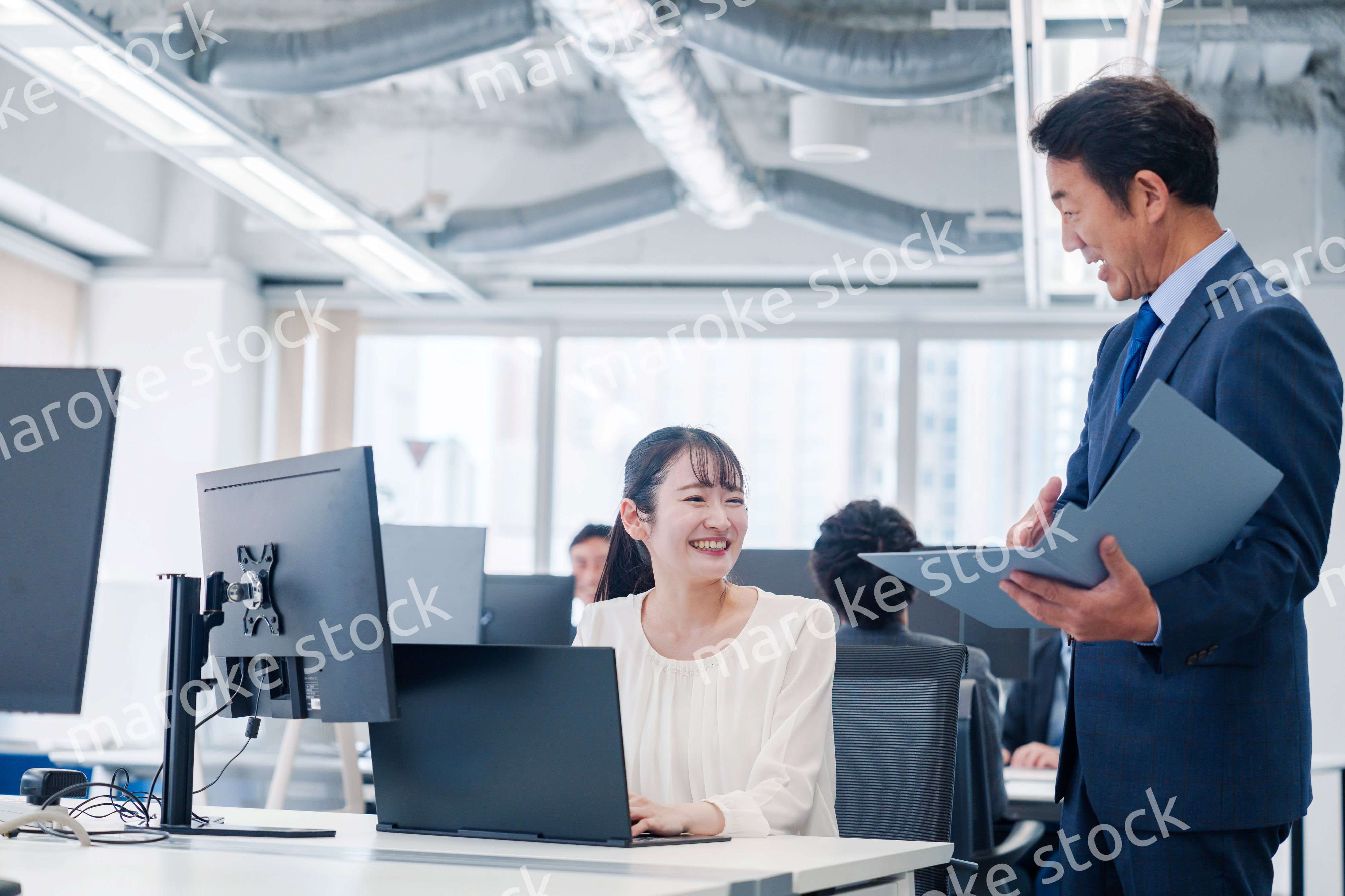 オフィスで上司と話をするビジネスウーマン