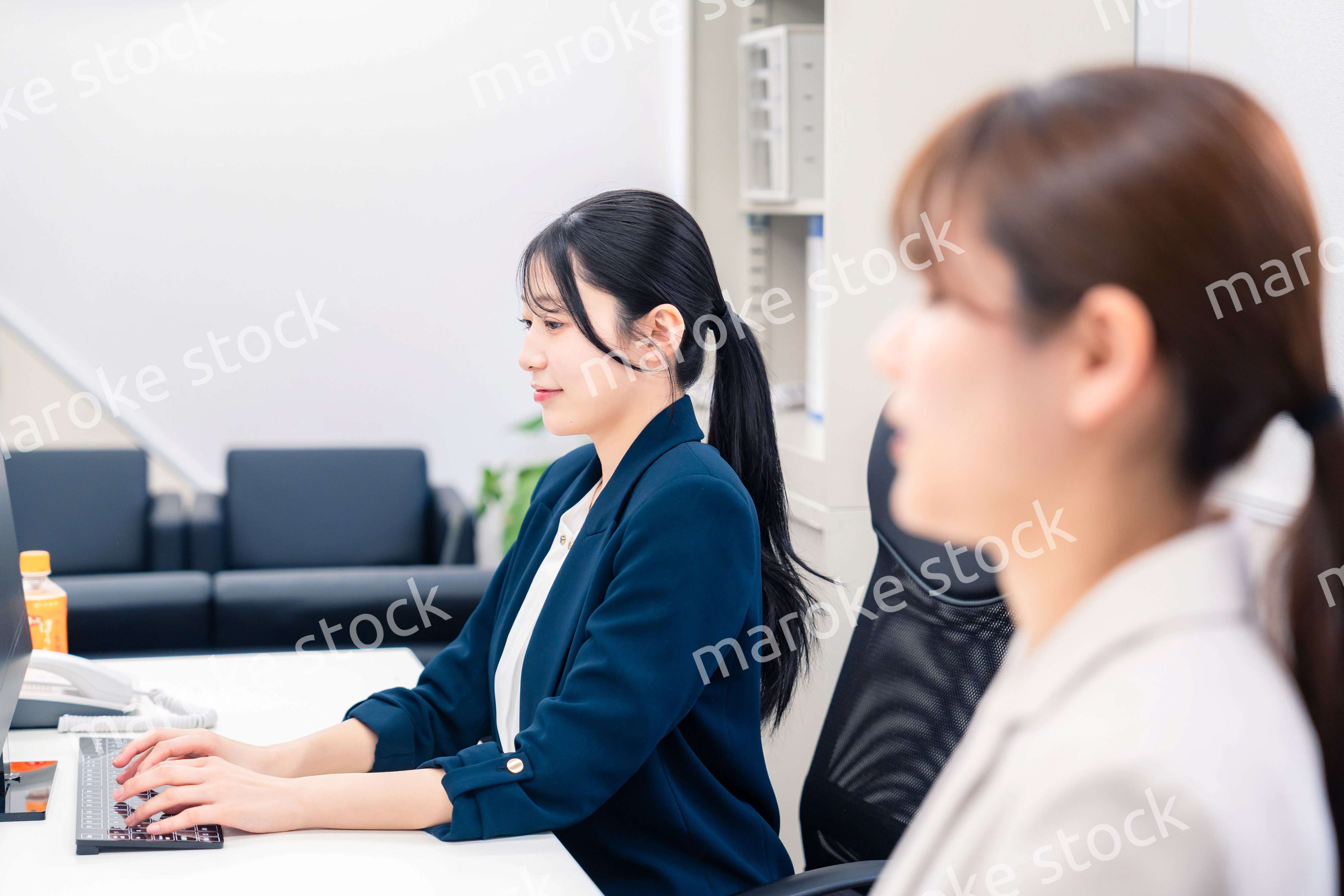 オフィスで事務の仕事をする若い女性社員