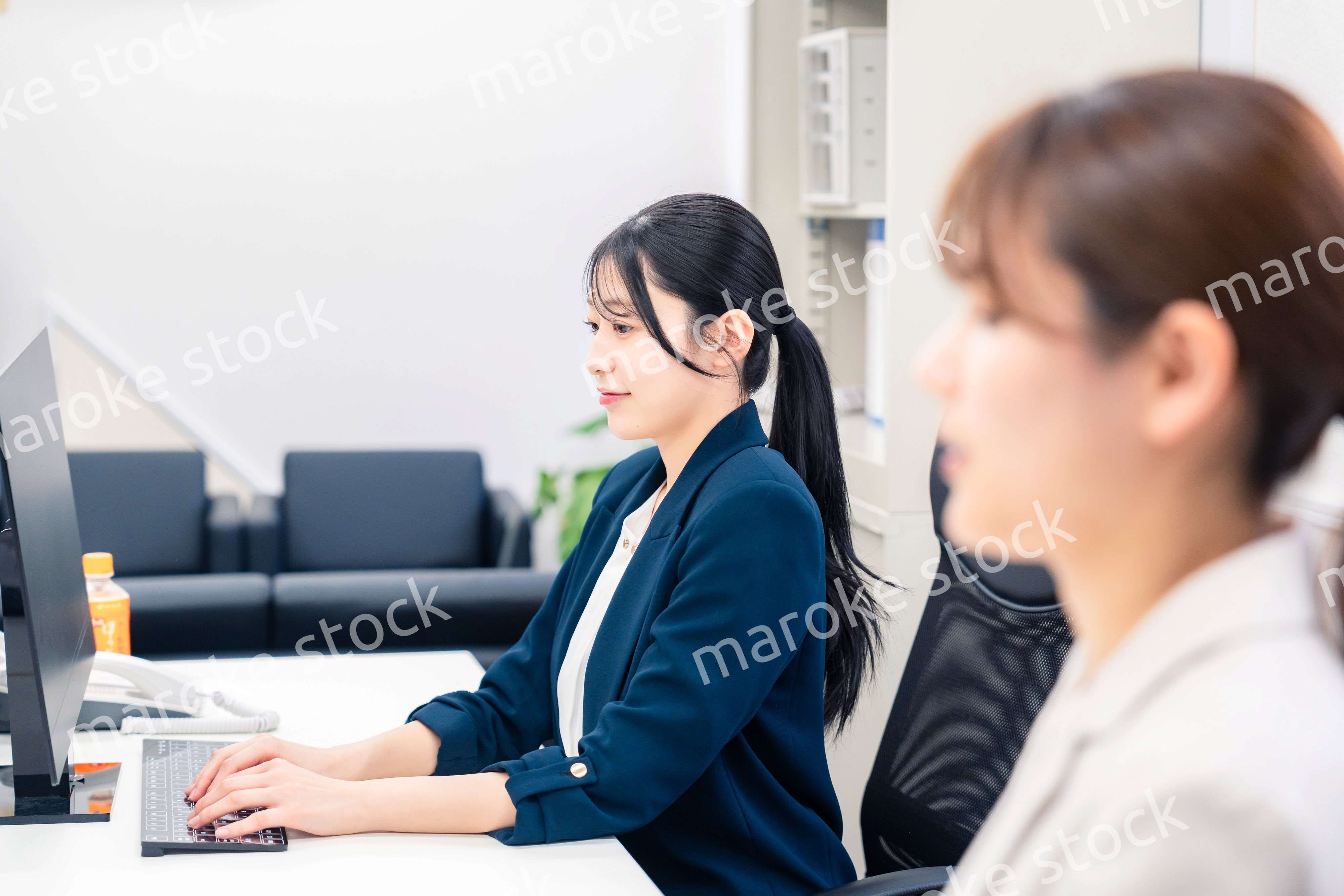 オフィスで事務の仕事をする若い女性社員