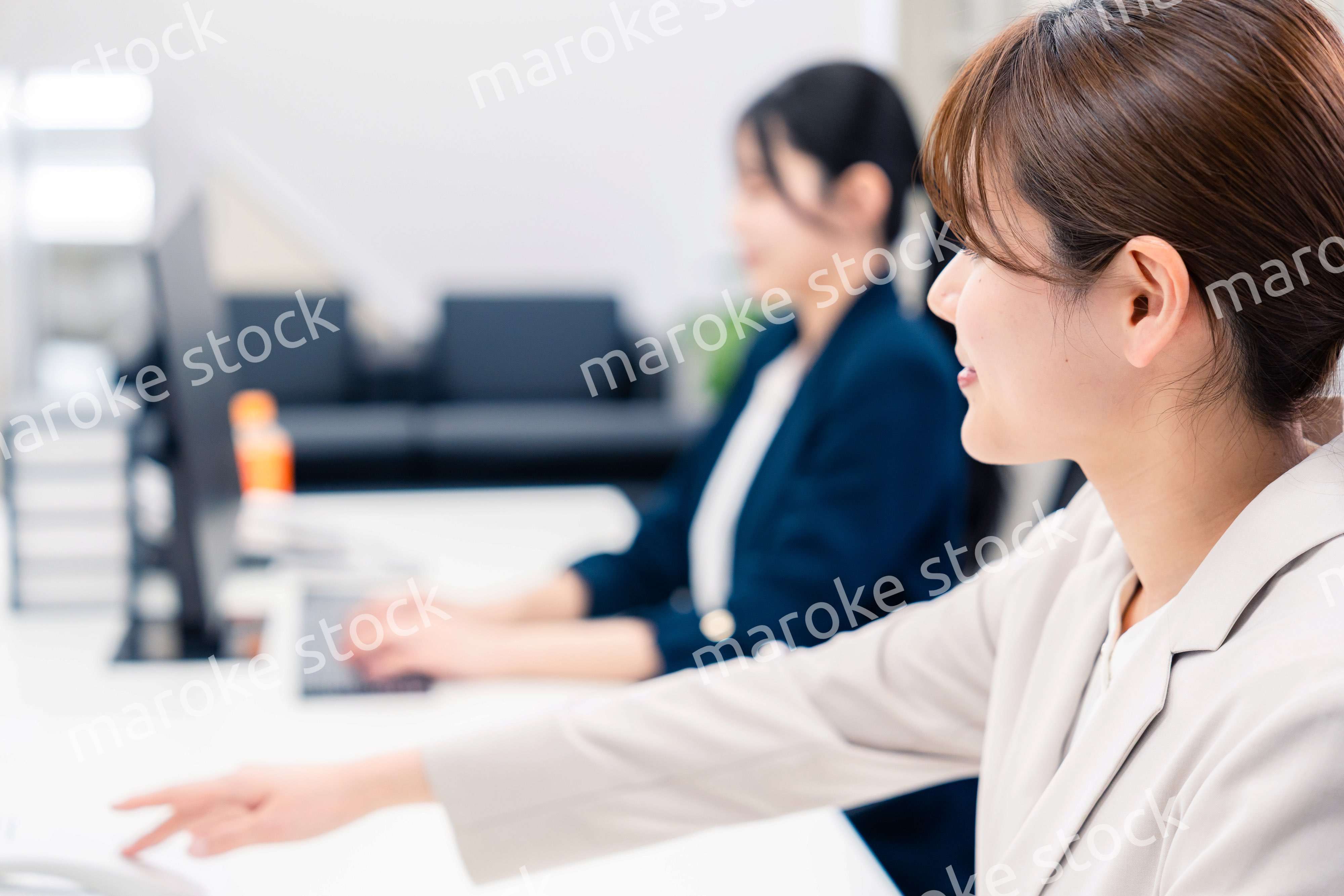 オフィスで事務の仕事をする若い女性社員