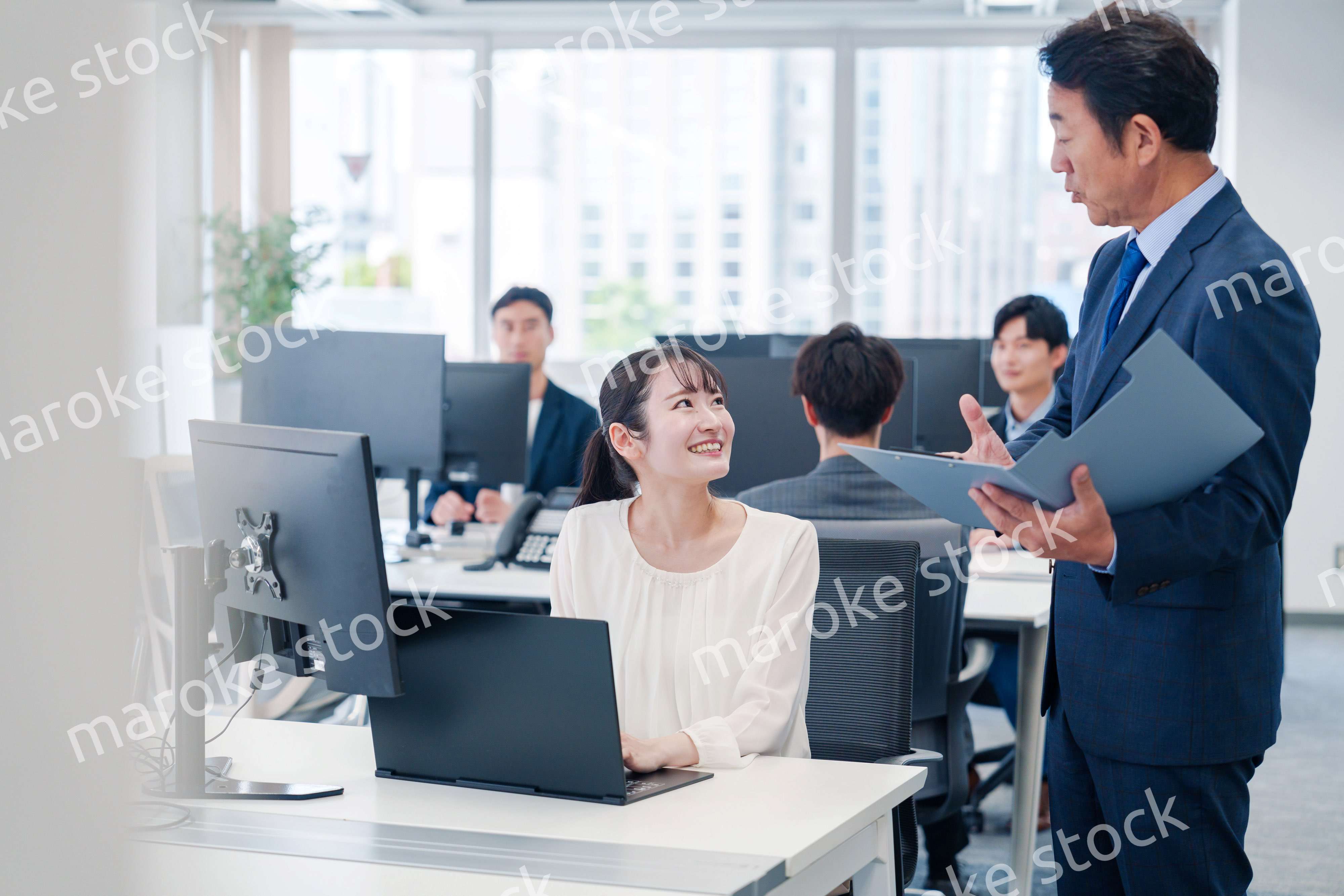 オフィスで上司と話をするビジネスウーマン