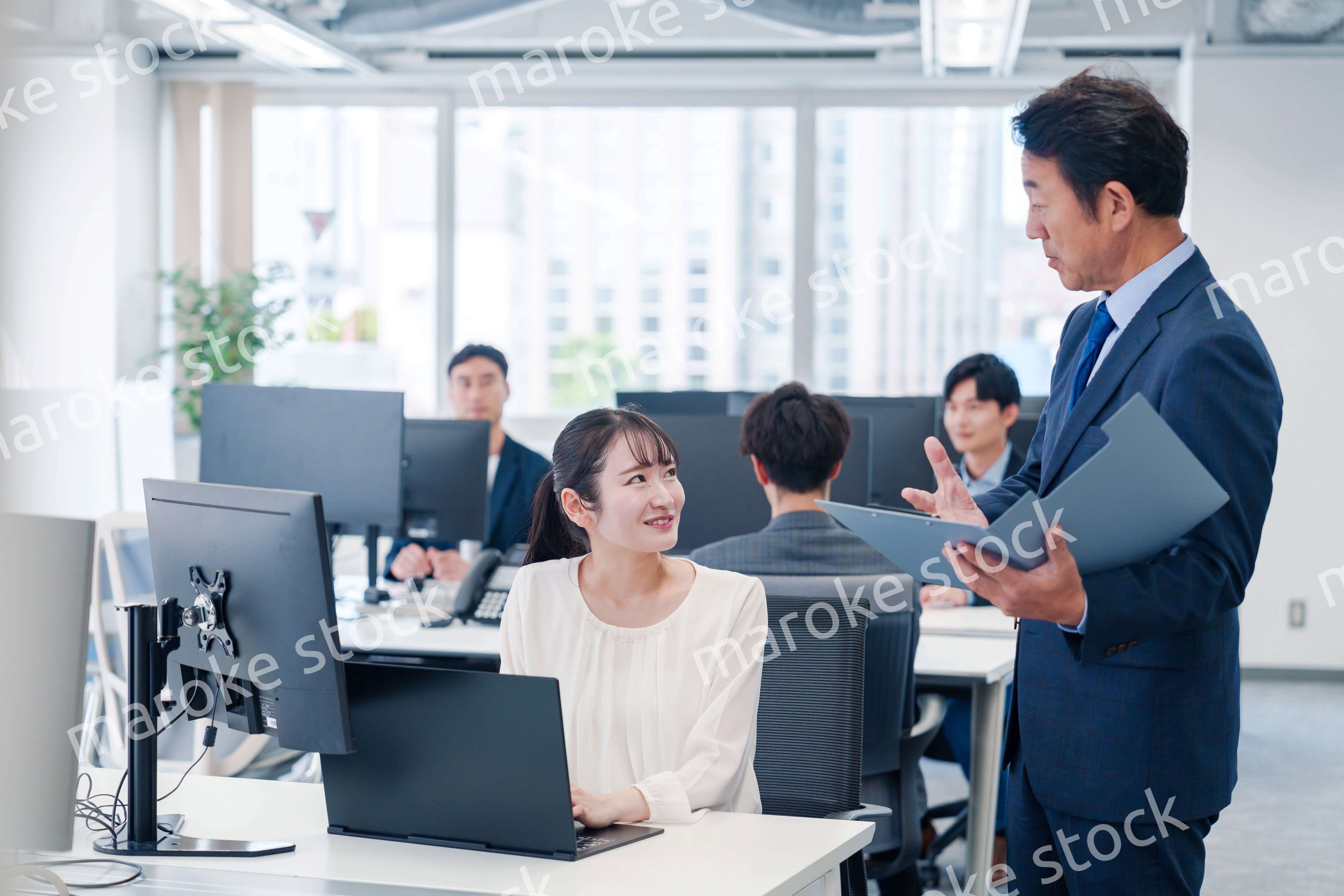 オフィスで上司と話をするビジネスウーマン