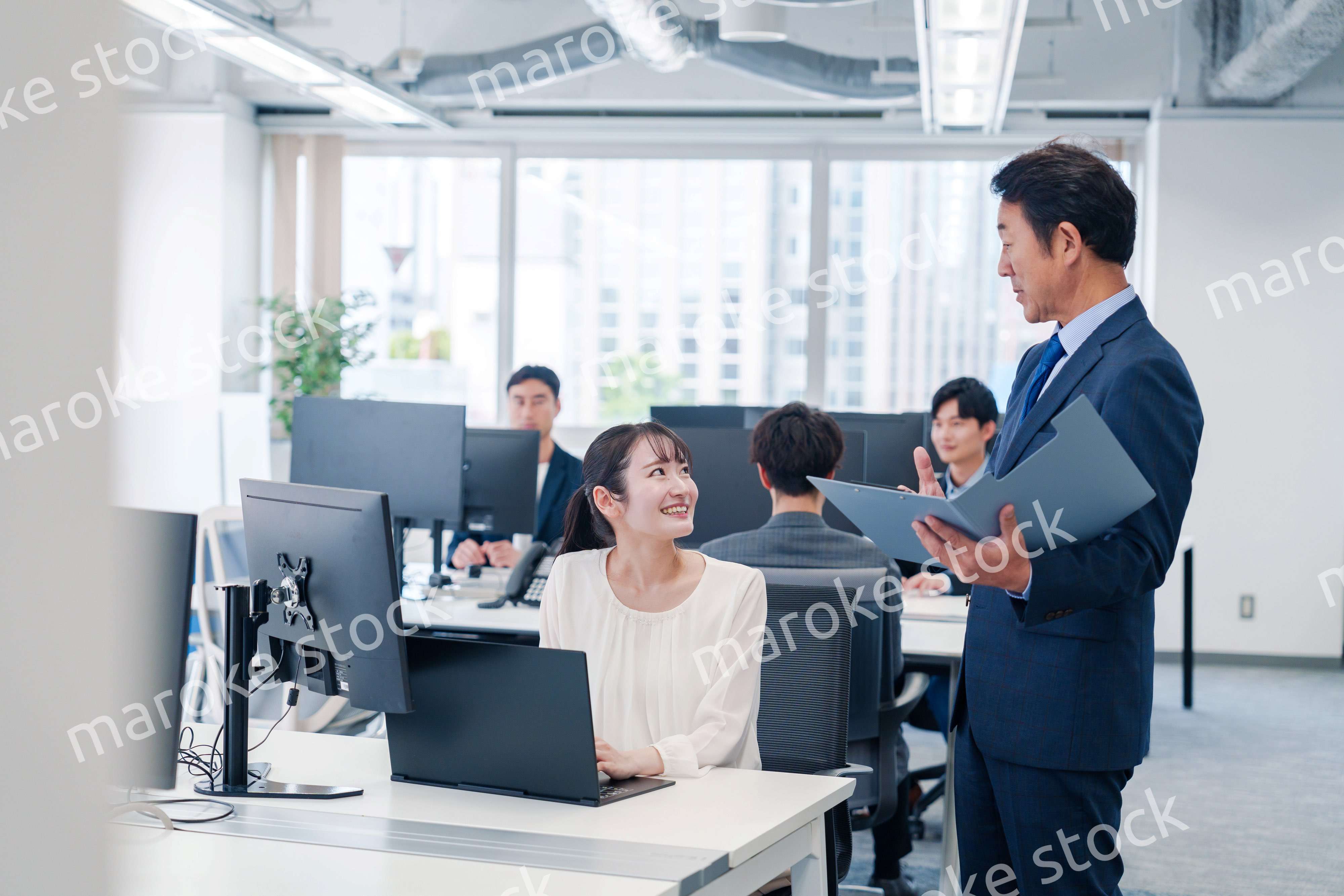 オフィスで上司と話をするビジネスウーマン