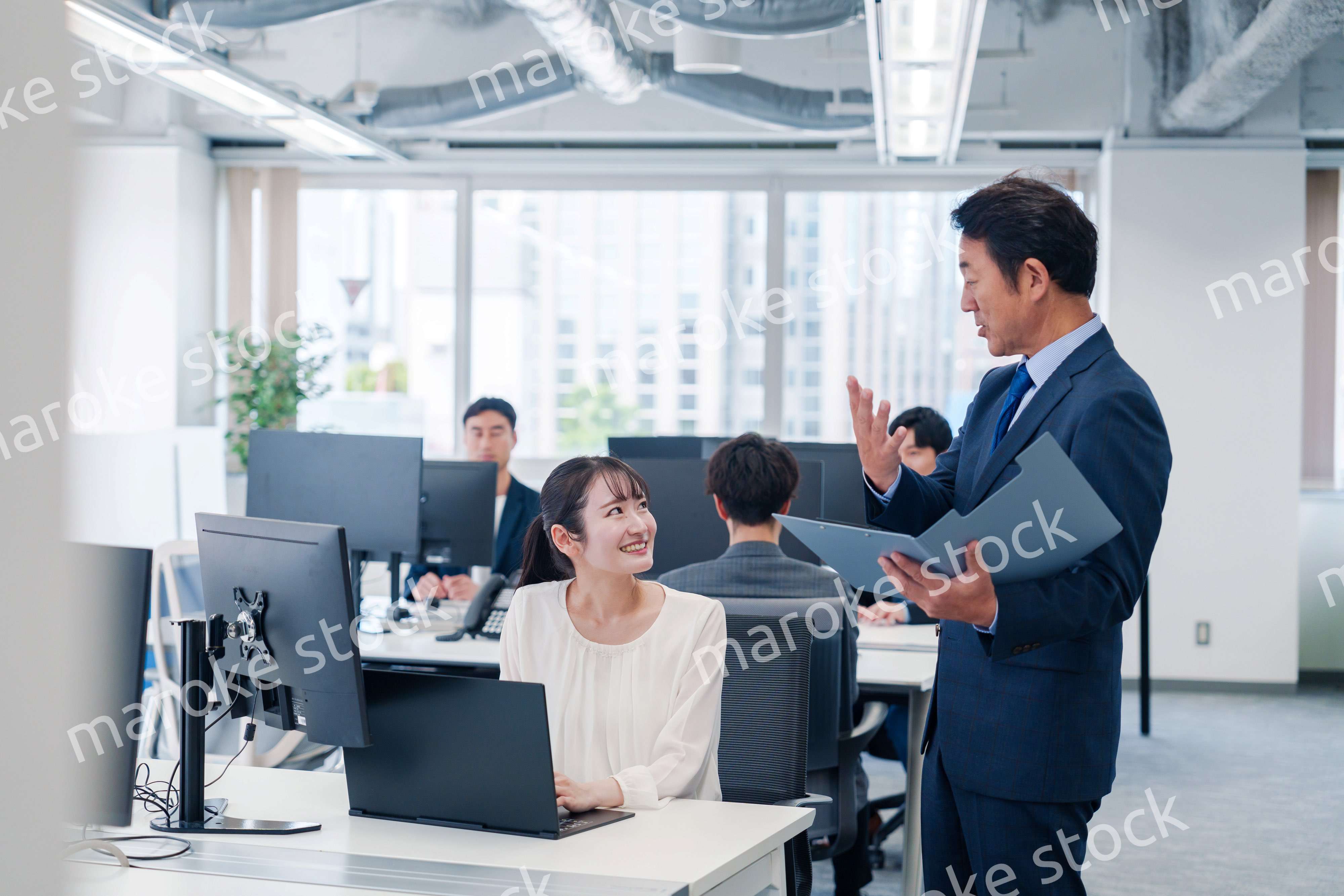 オフィスで上司と話をするビジネスウーマン