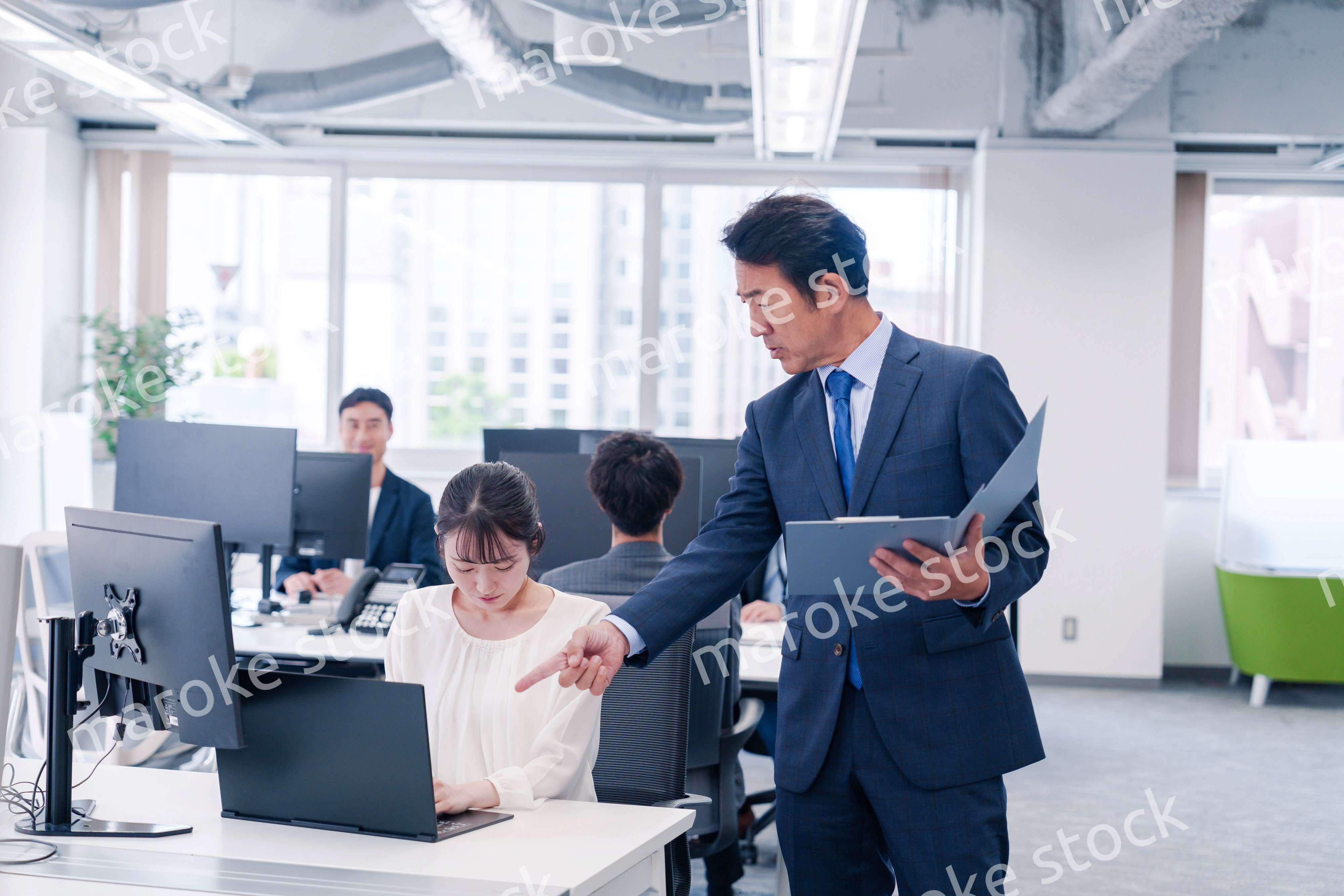 オフィスで上司から叱責をされる若い女性社員