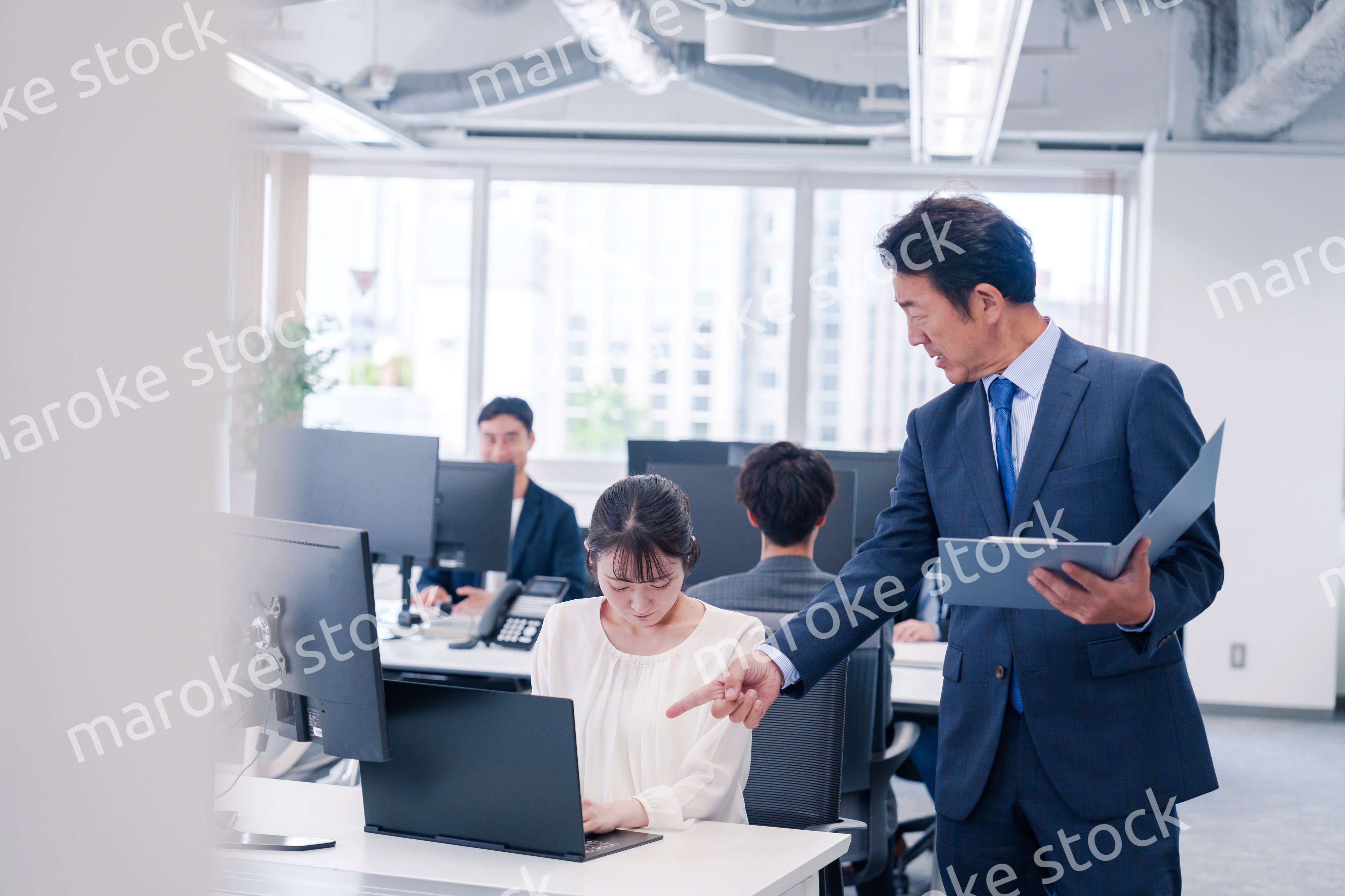 オフィスで上司から叱責をされる若い女性社員