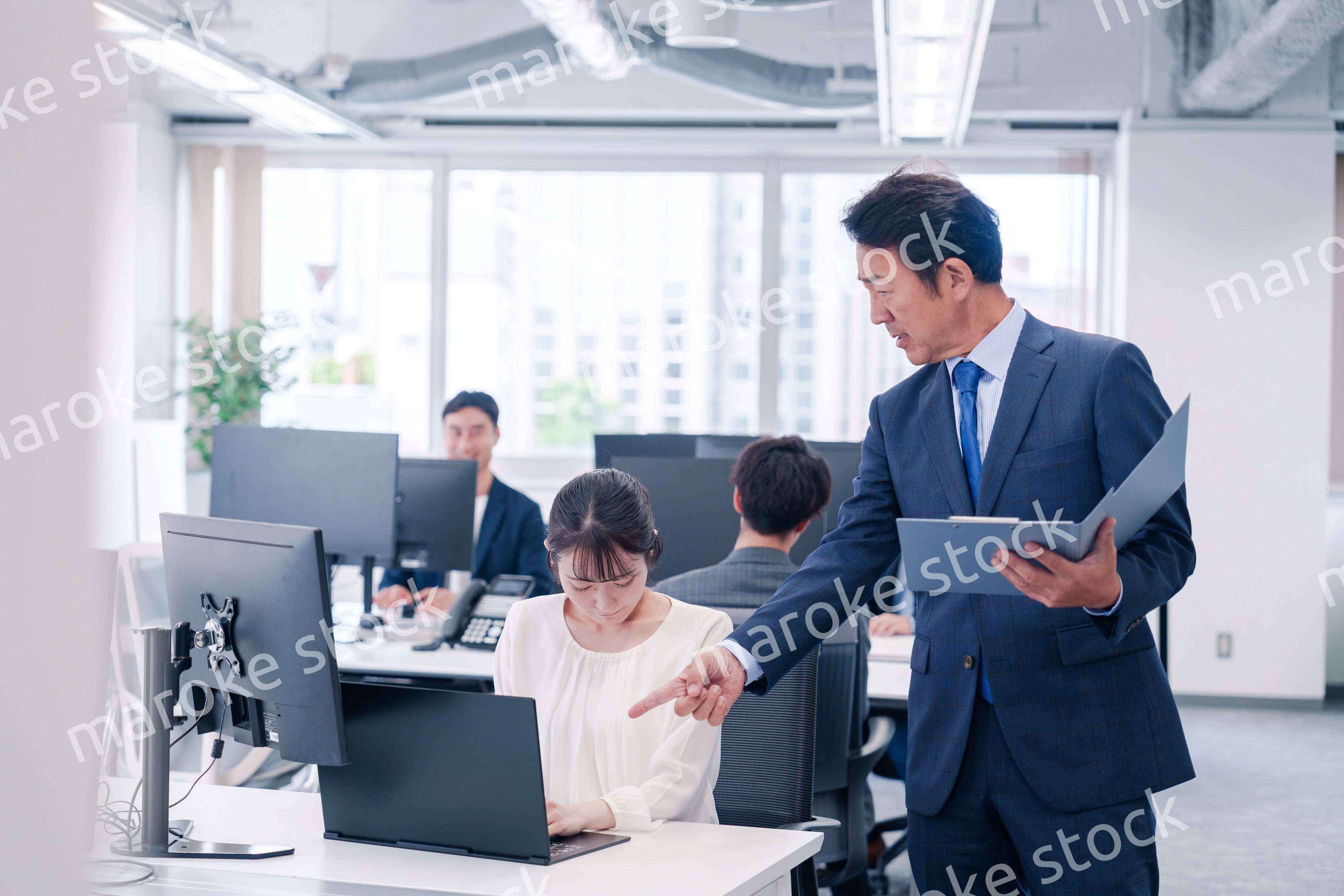 オフィスで上司から叱責をされる若い女性社員