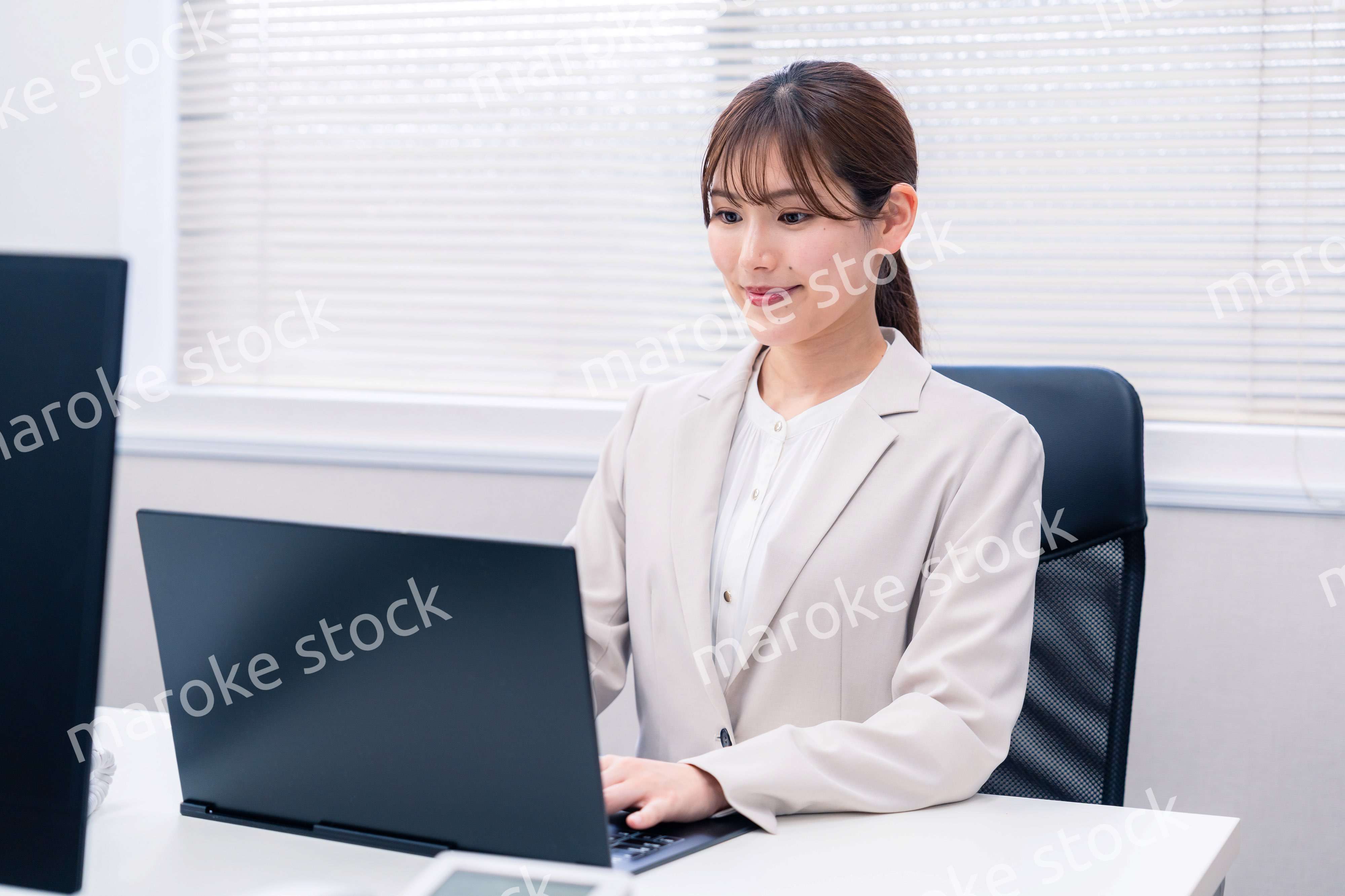 役所でデスクワークをする公務員の若い女性