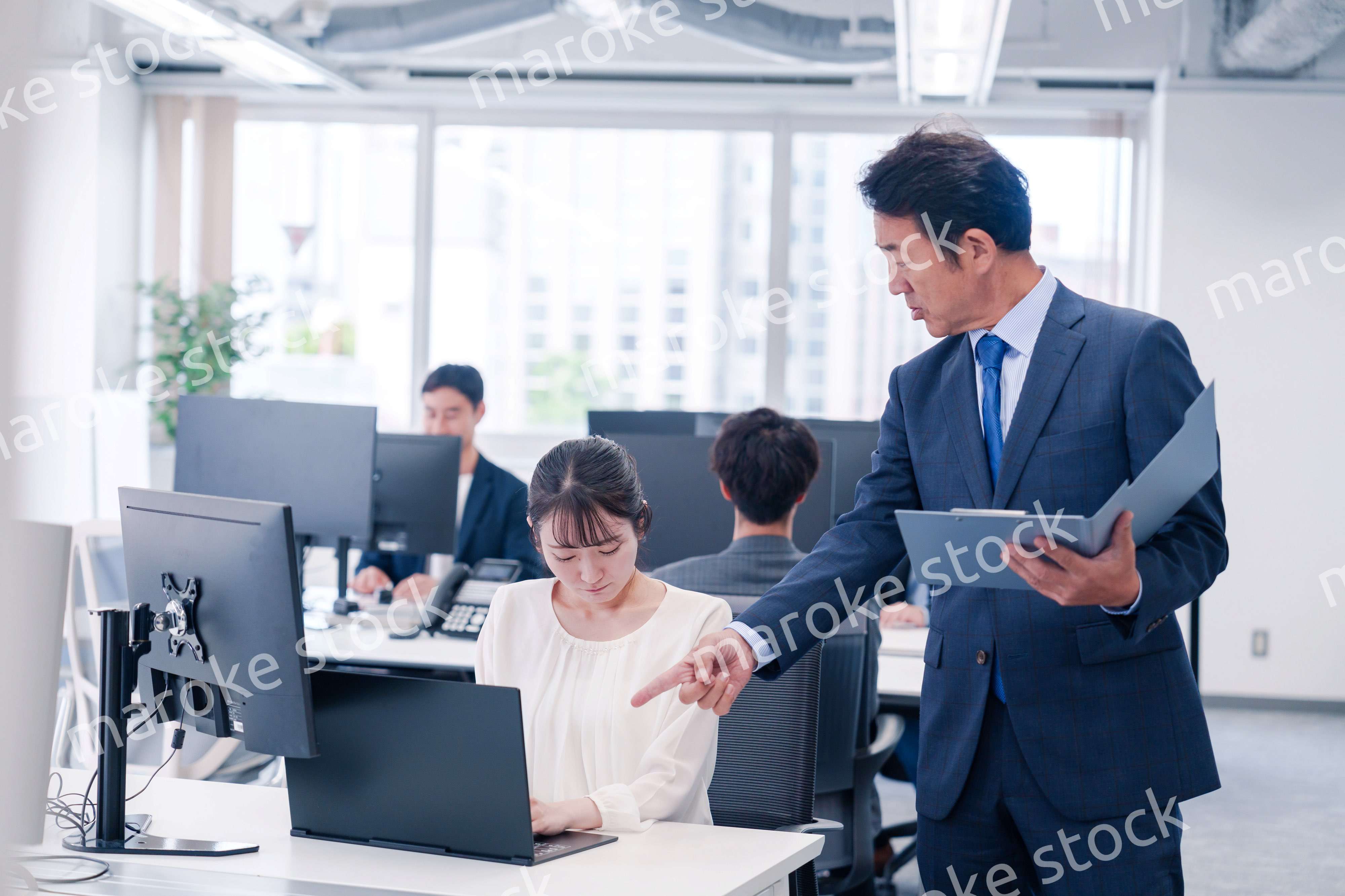 オフィスで上司から叱責をされる若い女性社員