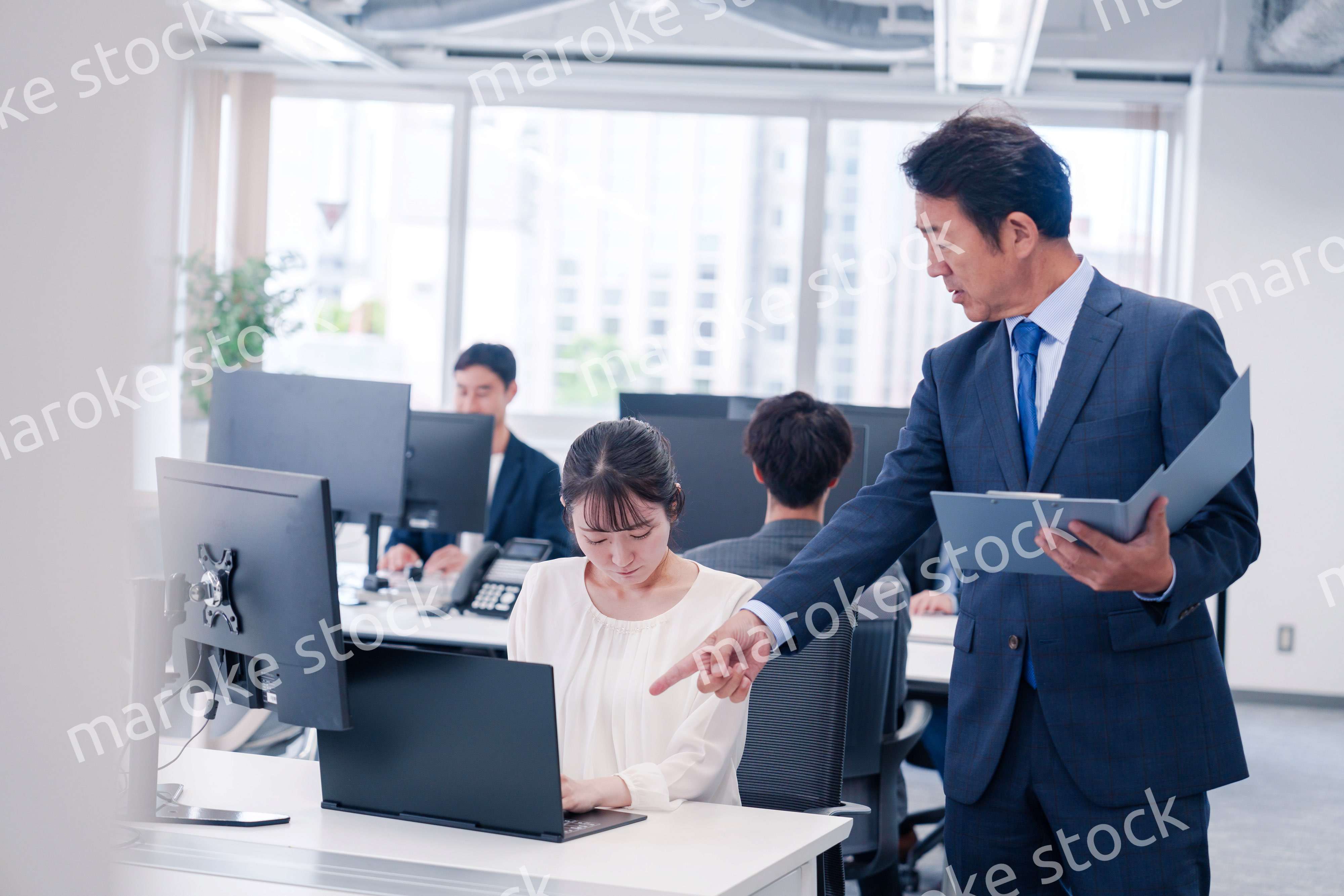 オフィスで上司から叱責をされる若い女性社員