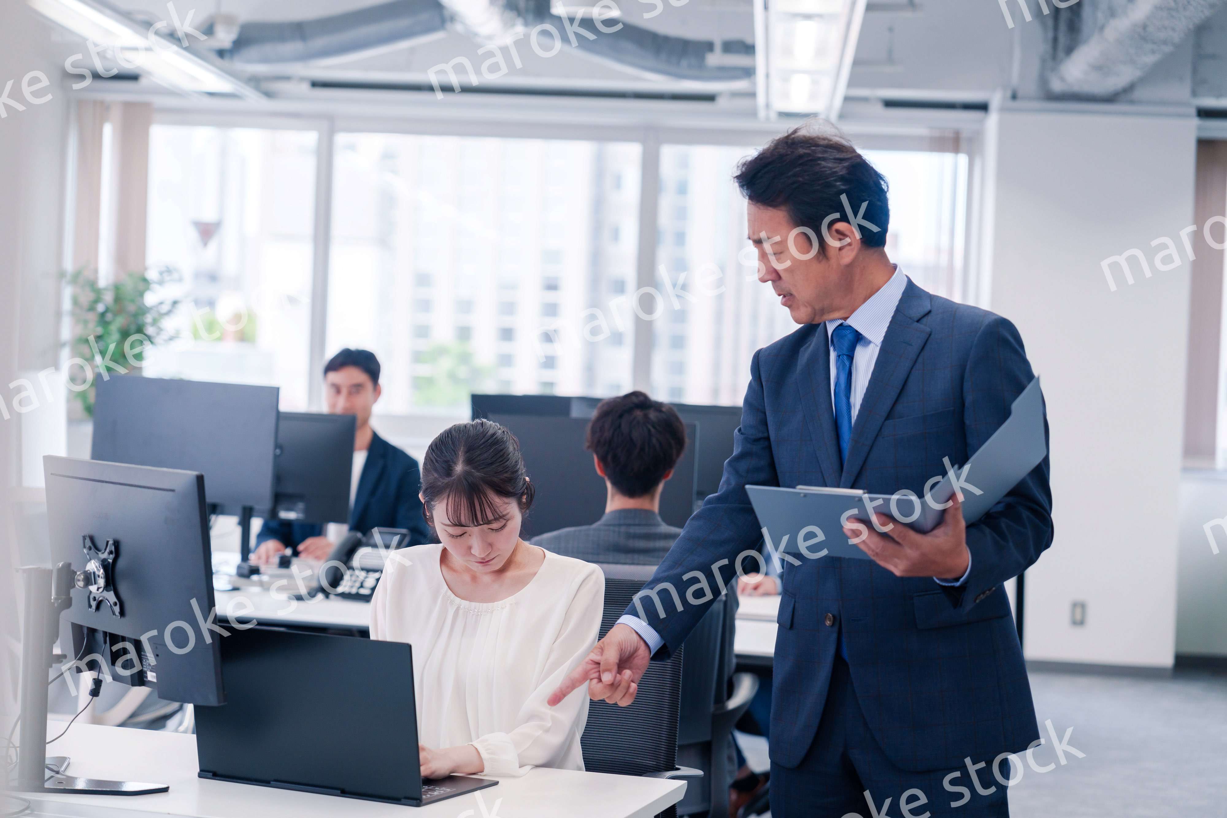 オフィスで上司から叱責をされる若い女性社員