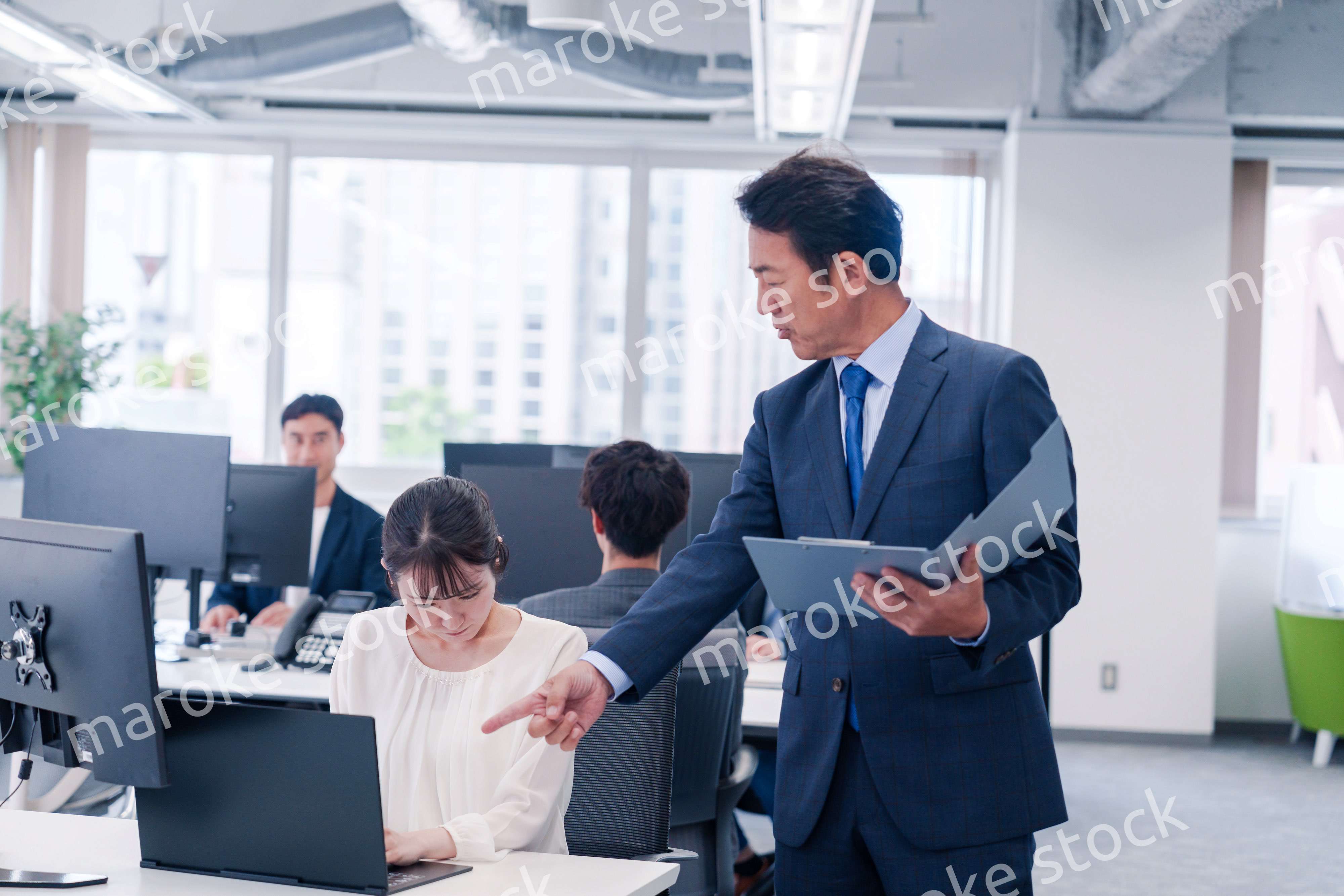 オフィスで上司から叱責をされる若い女性社員