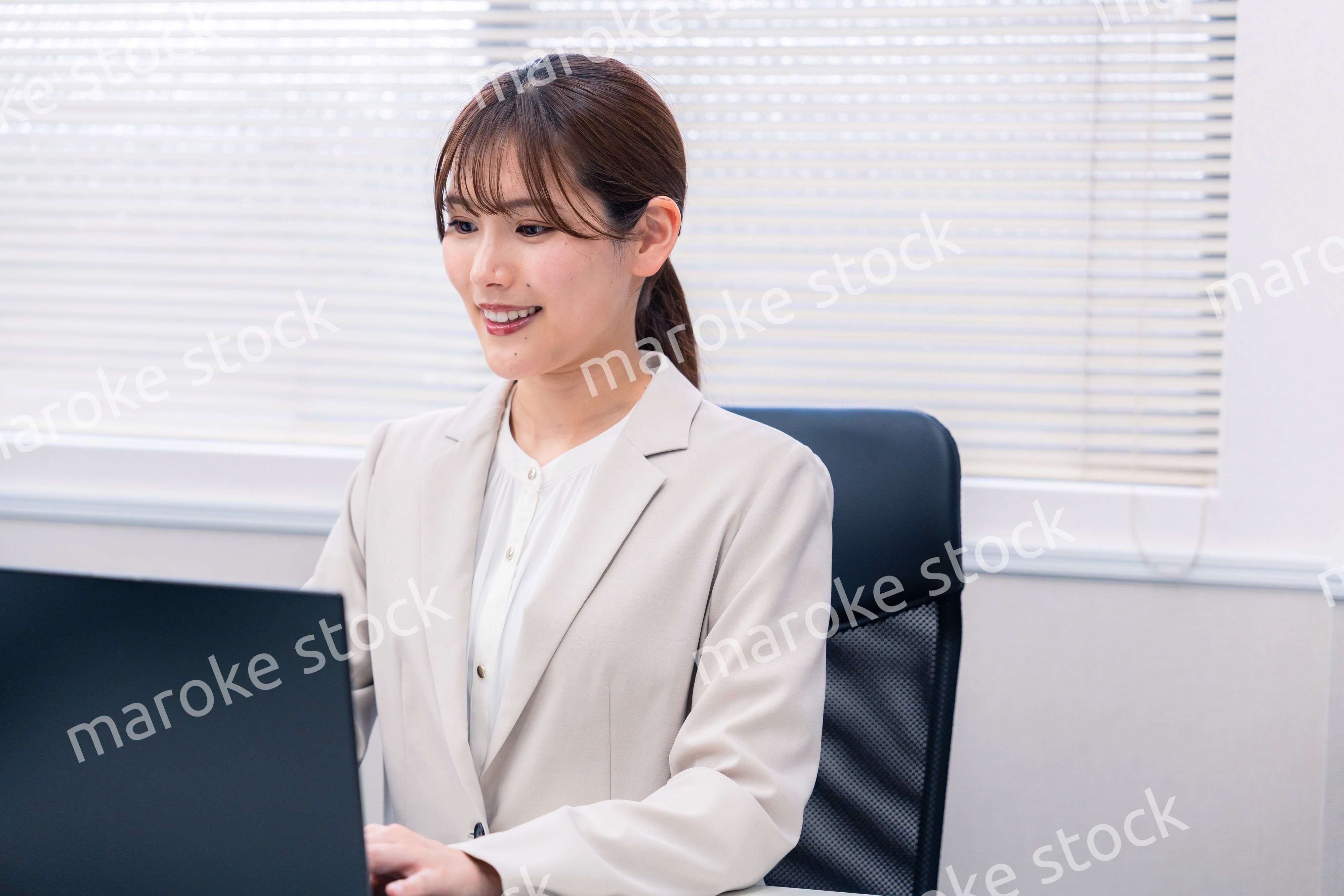 役所でデスクワークをする公務員の若い女性