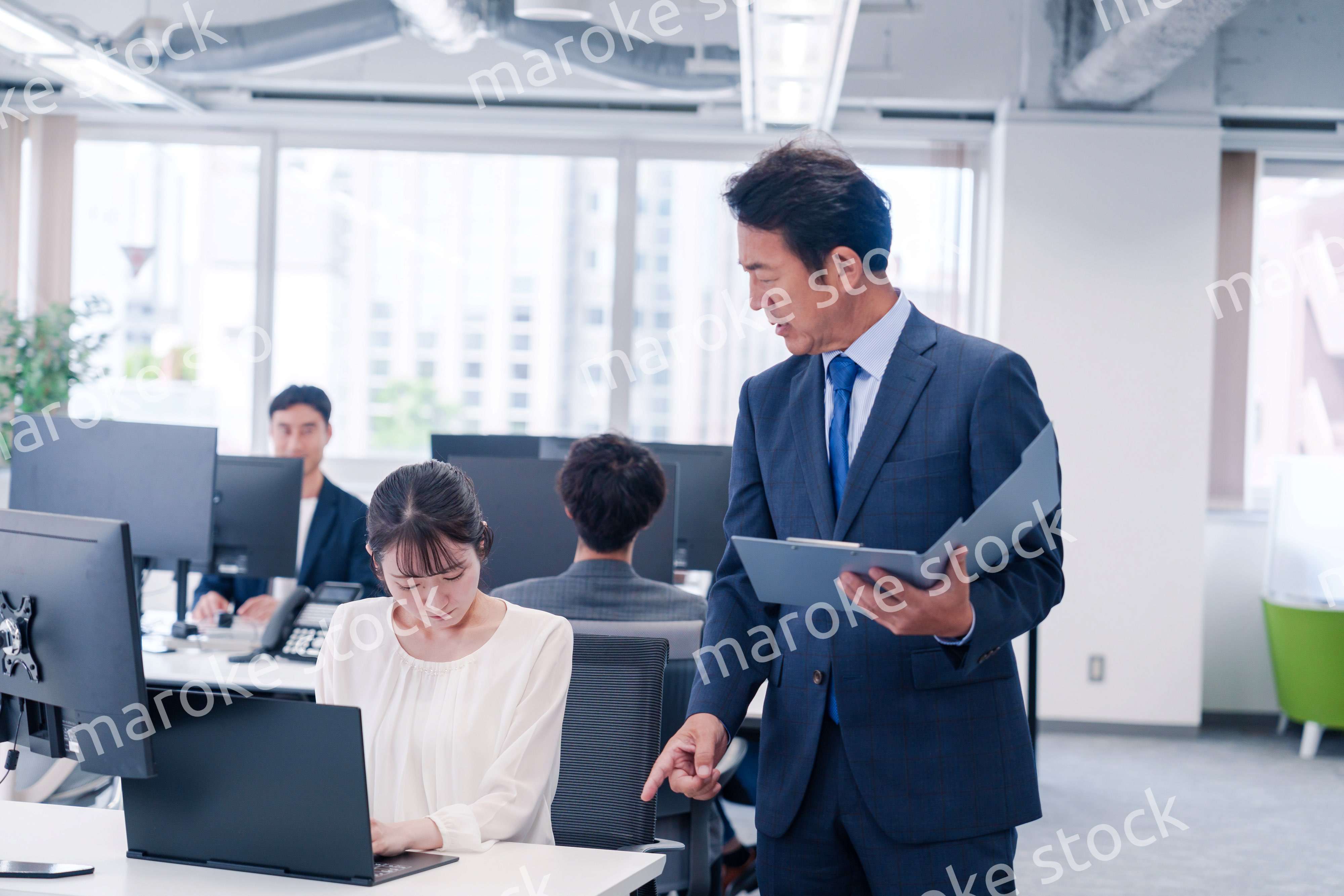 オフィスで上司から叱責をされる若い女性社員