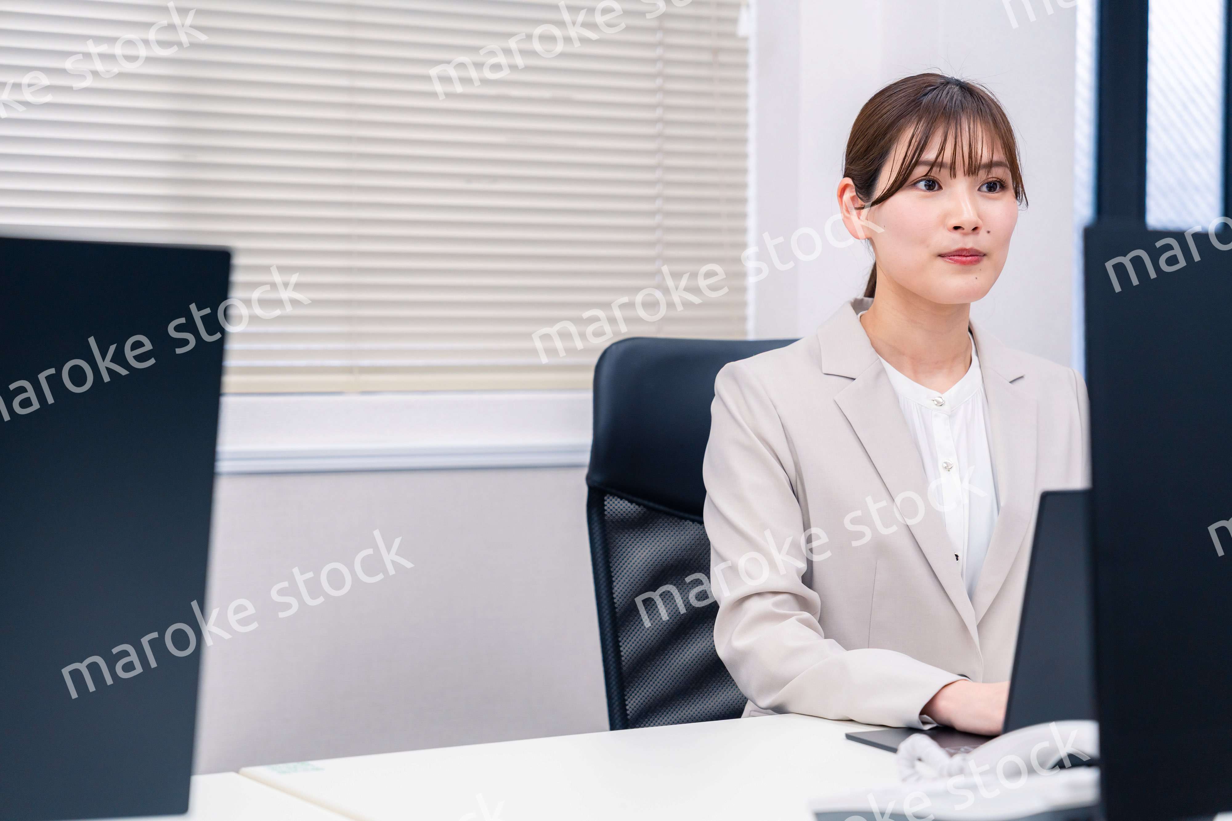 役所でデスクワークをする公務員の若い女性