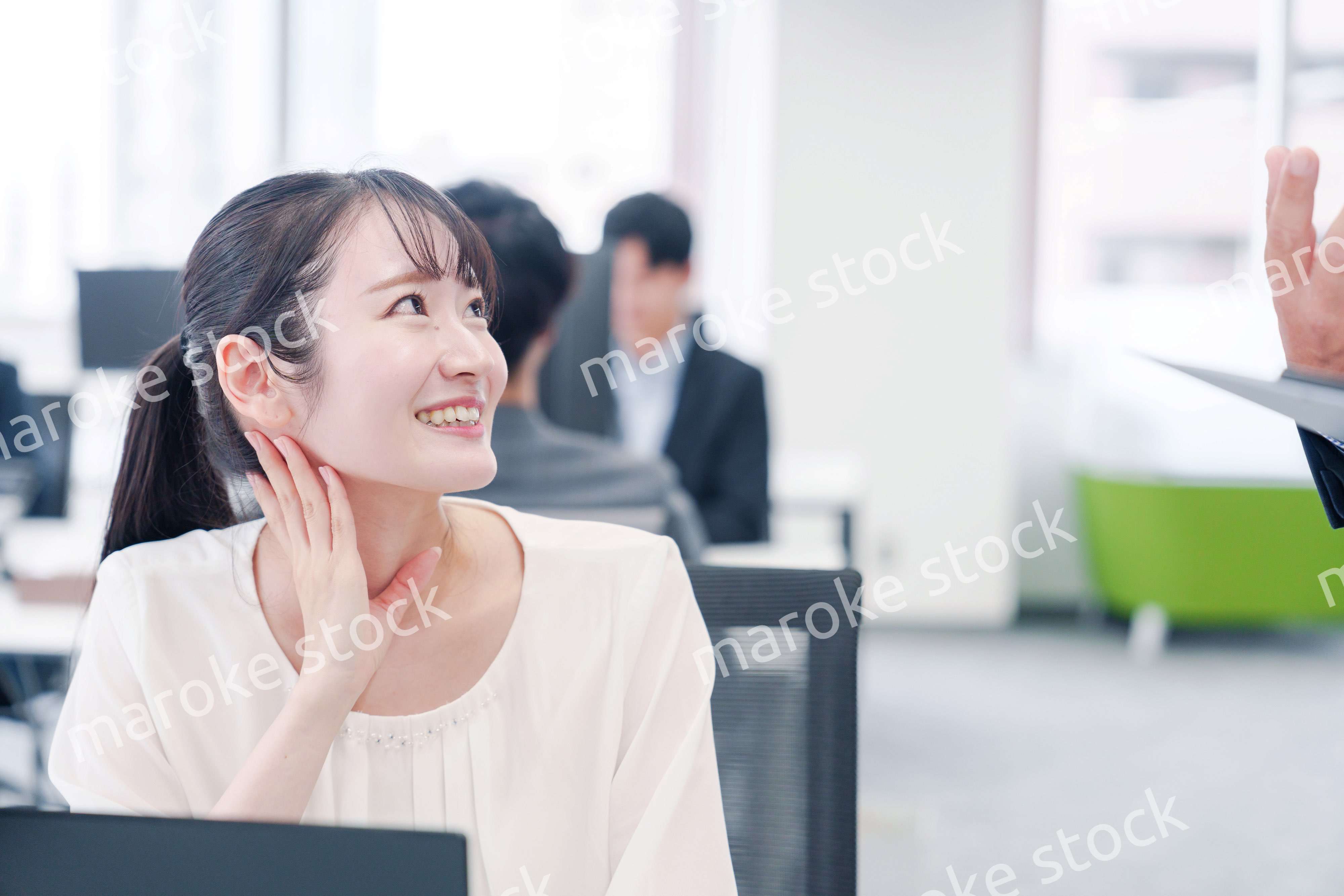 オフィスで楽しく雑談をする若い女性